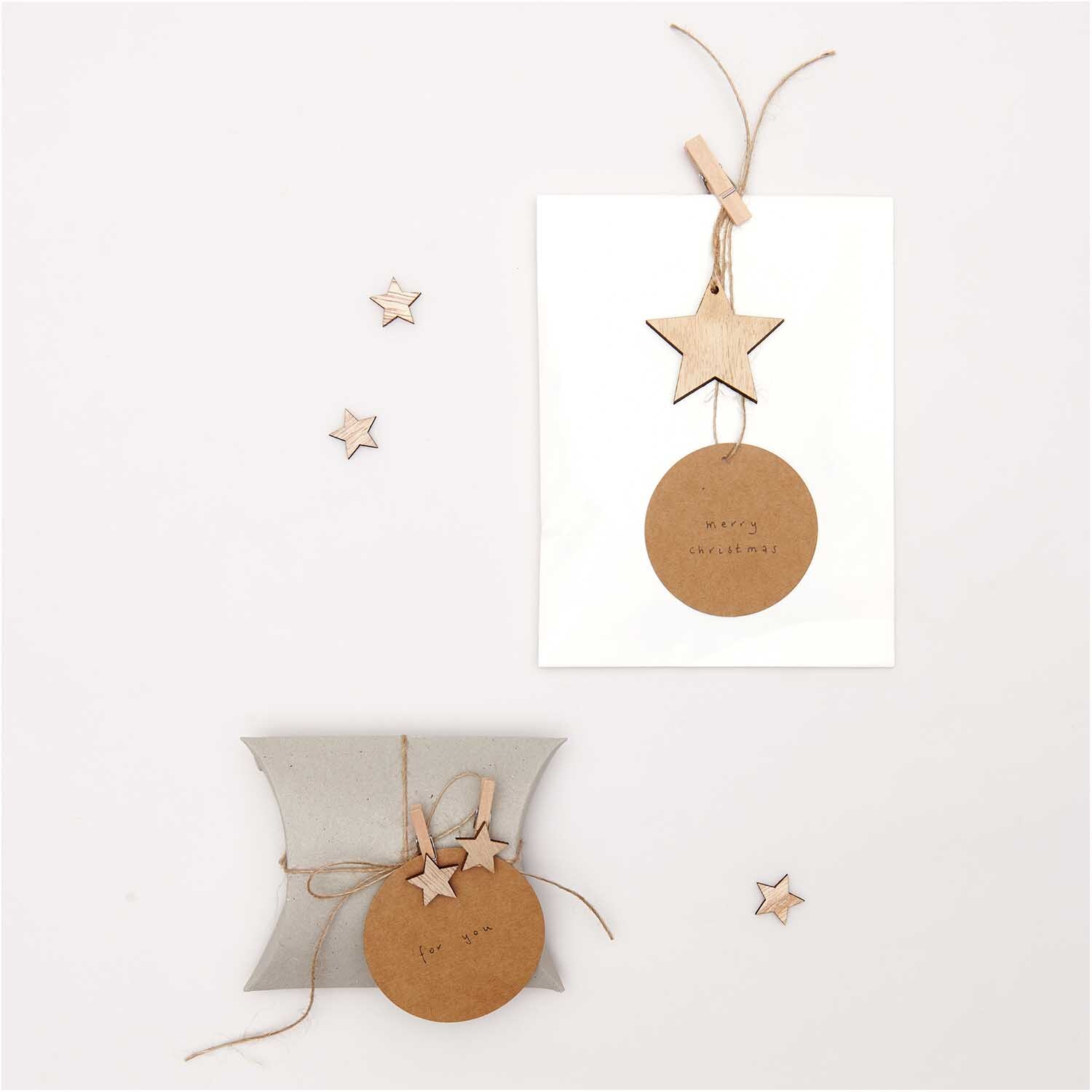 Dekoklammern Stern natur 3cm 8 Stück von Rico Design, dekoriert auf Geschenkverpackung und Karte.
