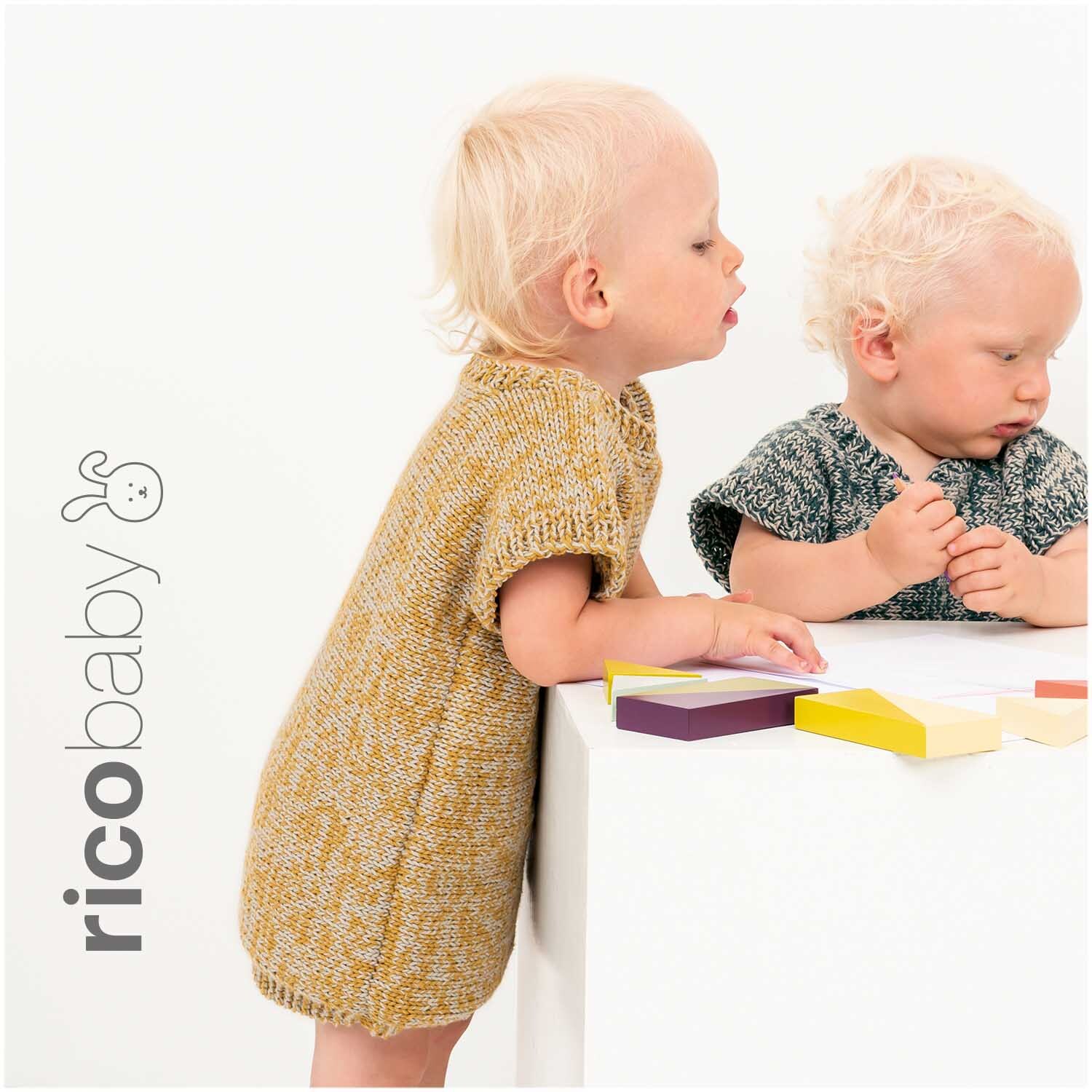 Rico Baby Cotton Soft dk: Zwei Kleinkinder in gestrickten Outfits spielen mit bunten Holzklötzen.