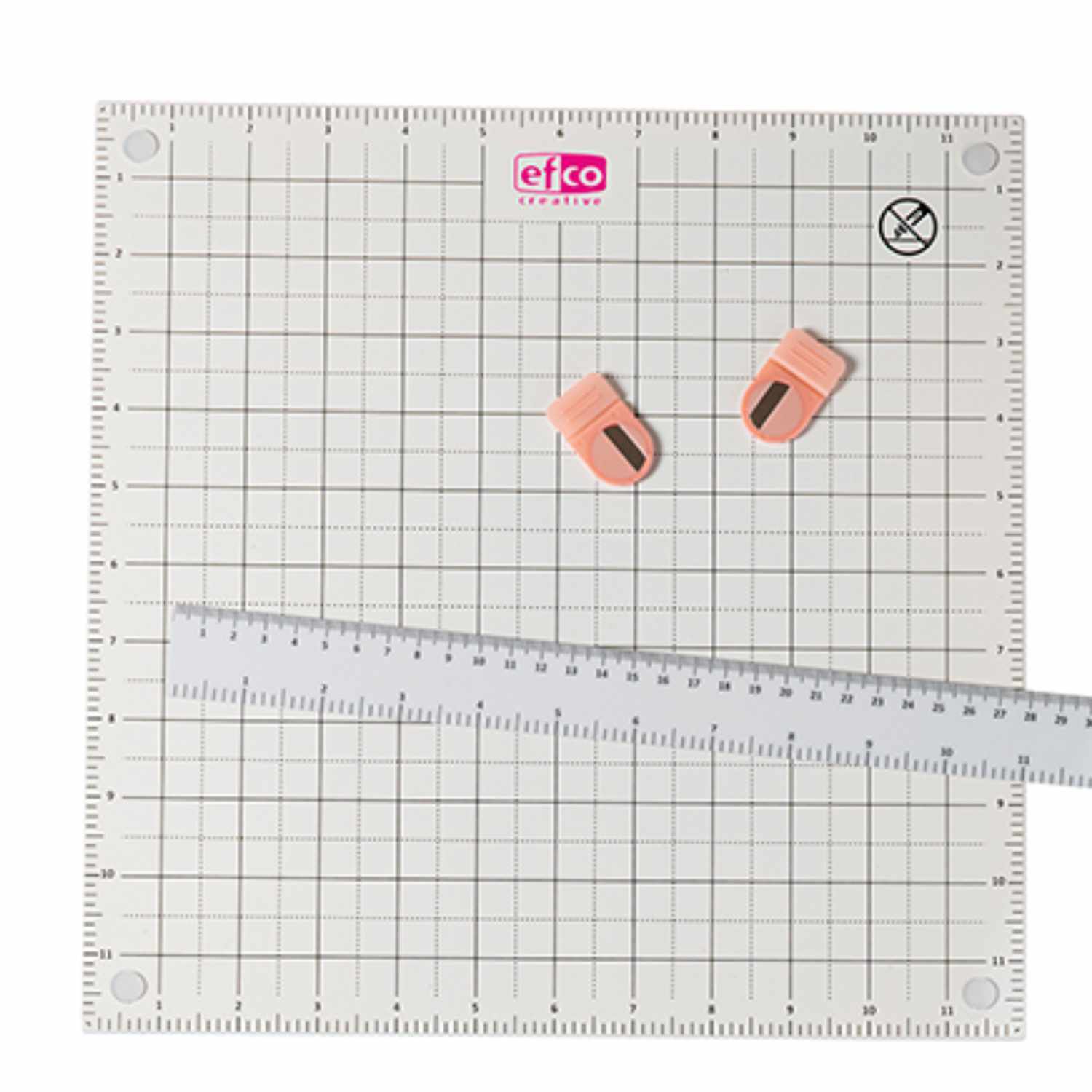 Papierwerkstatt magnetisch 30,5x30,5cm von efco, mit Lineal und zwei Clips auf kariertem Hintergrund.