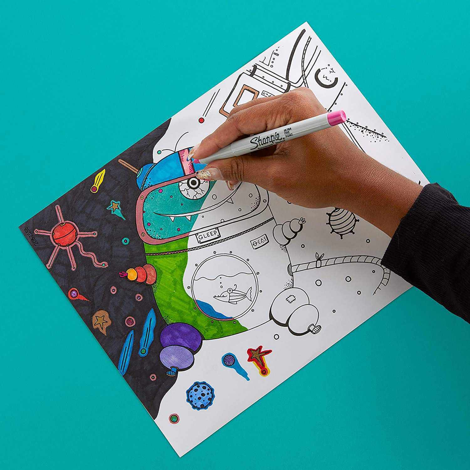 Permanentmarker fein Fun Farben 4 Stück: Hand zeichnet mit einem Sharpie auf einem bunten Weltraum-Malblatt.