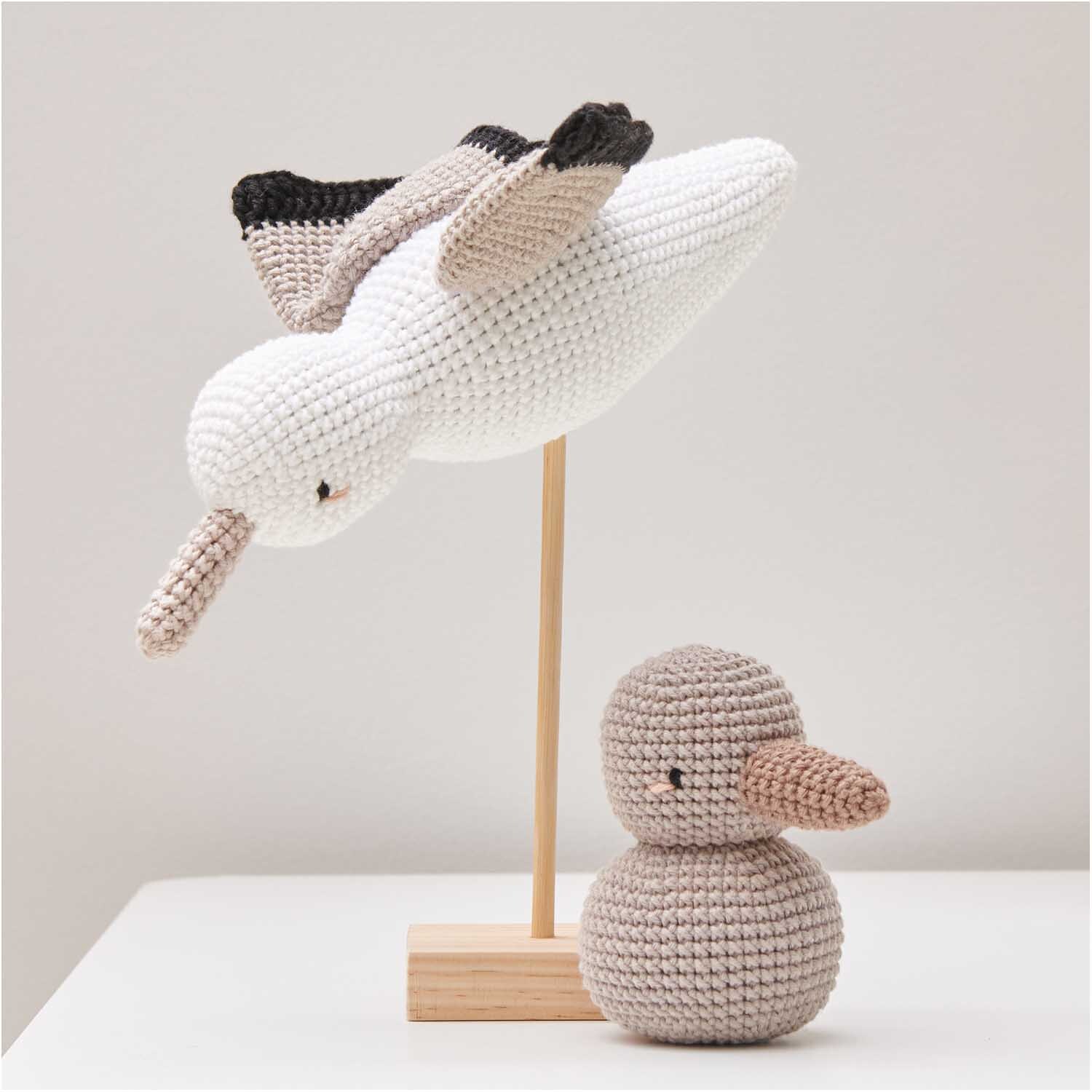 Creative Ricorumi dk: Zwei gehäkelte Vögel, einer fliegend, einer sitzend, in Perlgrau von Rico Design.