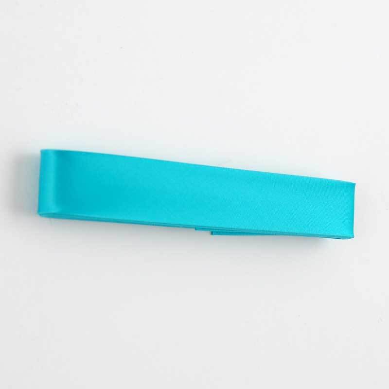 Schrägband 20mm Satin 2m in leuchtendem Türkisgrün von Gütermann, aufgerollt auf weißem Hintergrund.