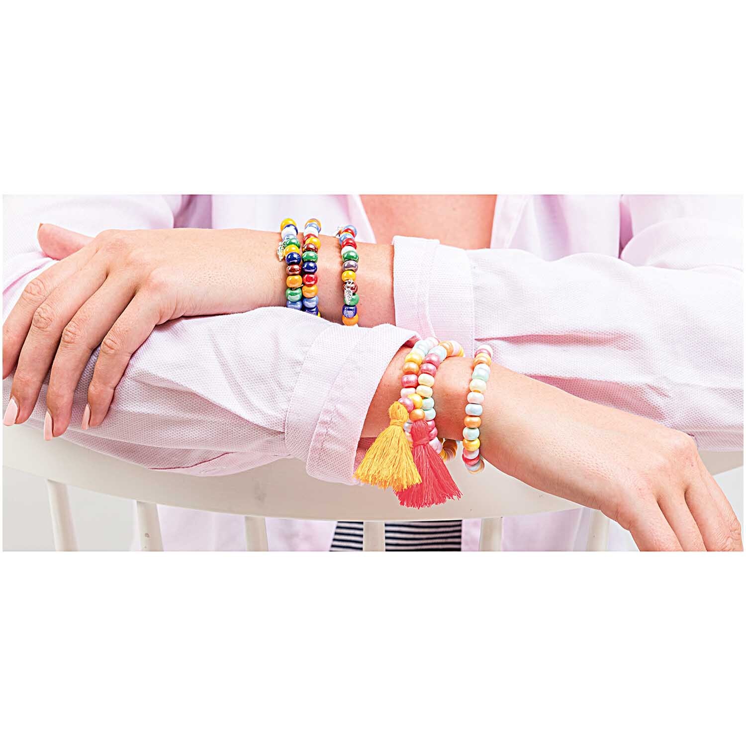 Glas-Perlen opak multicolor 8x5,5mm: Frau trägt bunte Armbänder aus opaken Glas-Perlen von Rico Design.