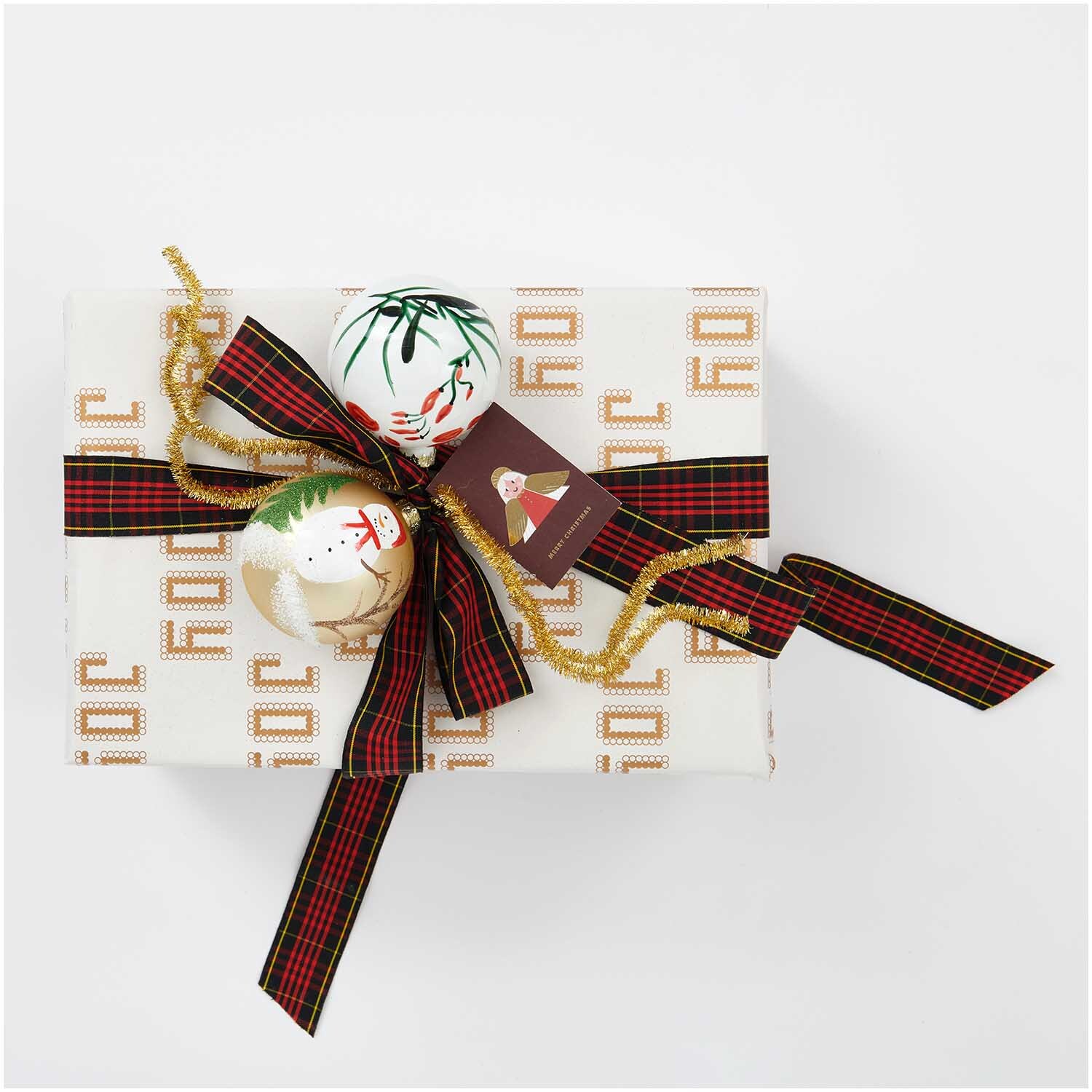 Paper Poetry Karoband verziert ein Geschenk mit weihnachtlichem Muster und goldener Schleife.
