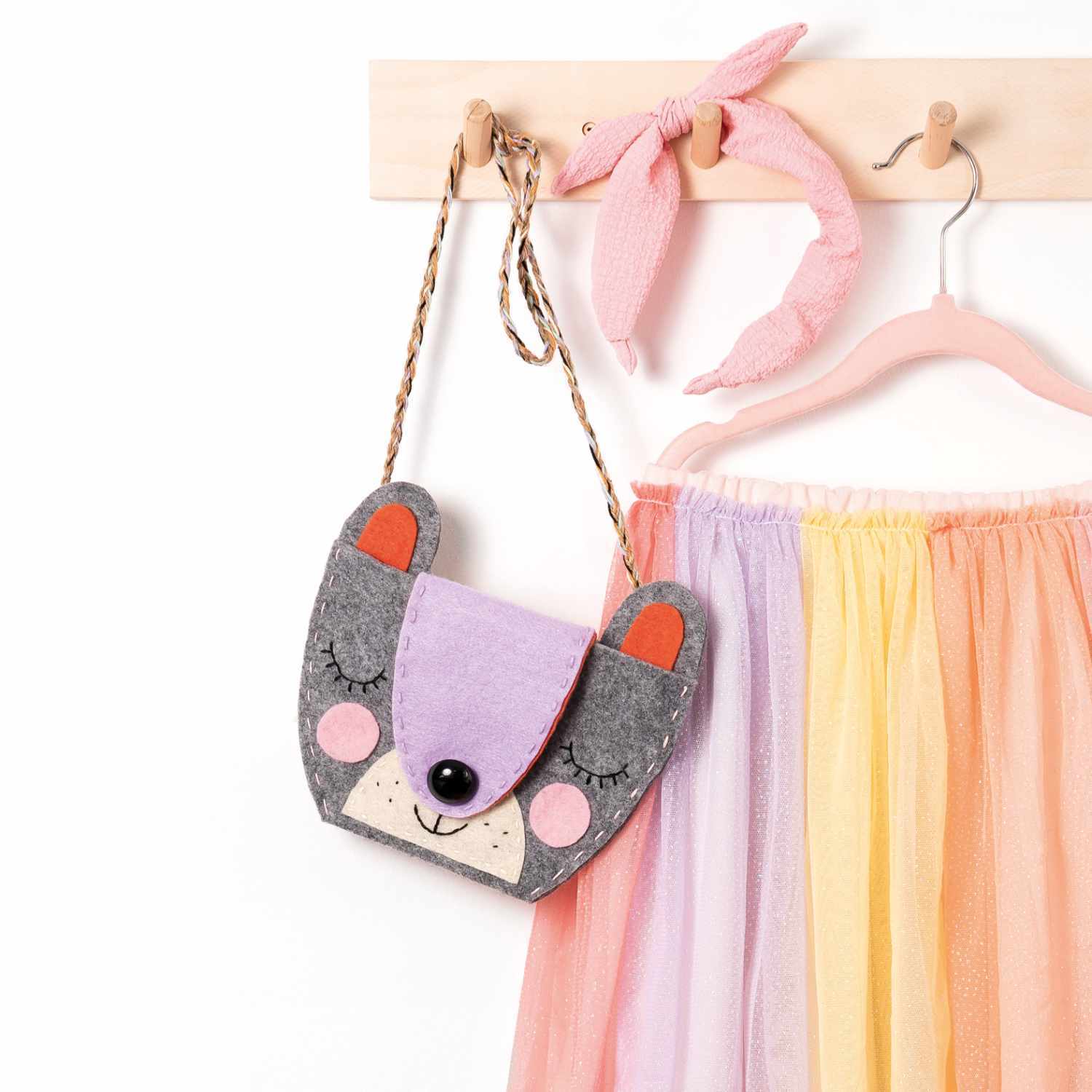 Filz-DIY-Box: Niedliche Filztasche in Tierform, 36-teilig, hängt neben einem bunten Rock und rosa Stirnband.