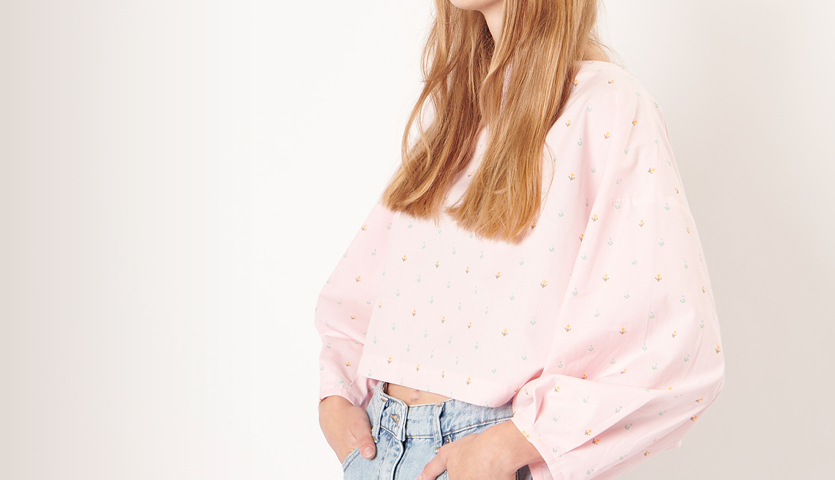 Nähanleitung Bluse mit Ballonärmeln: Frau trägt eine rosa Bluse mit weiten Ärmeln und Jeans.