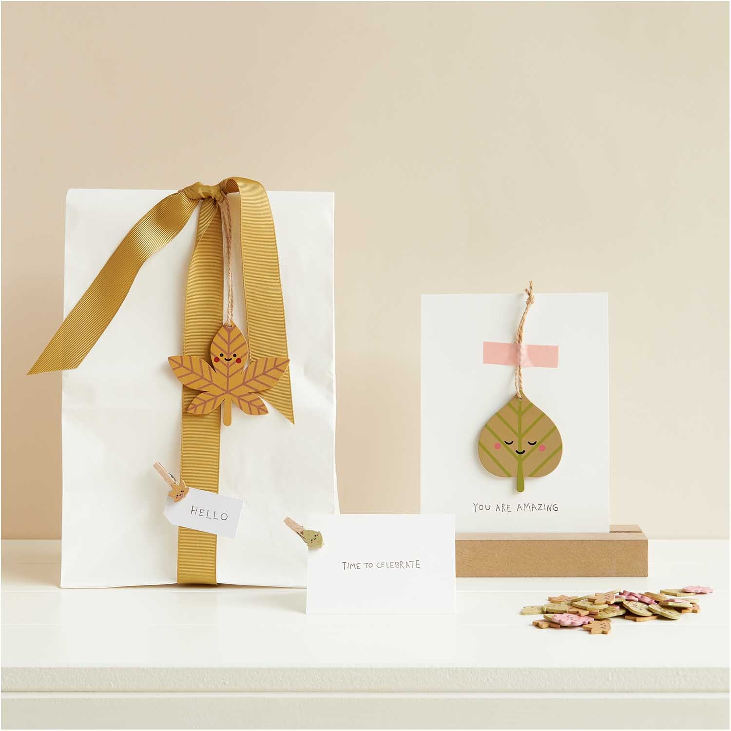 Holzanhänger Herbstblatt grün von Rico Design auf Geschenkverpackung und Karte dekoriert.