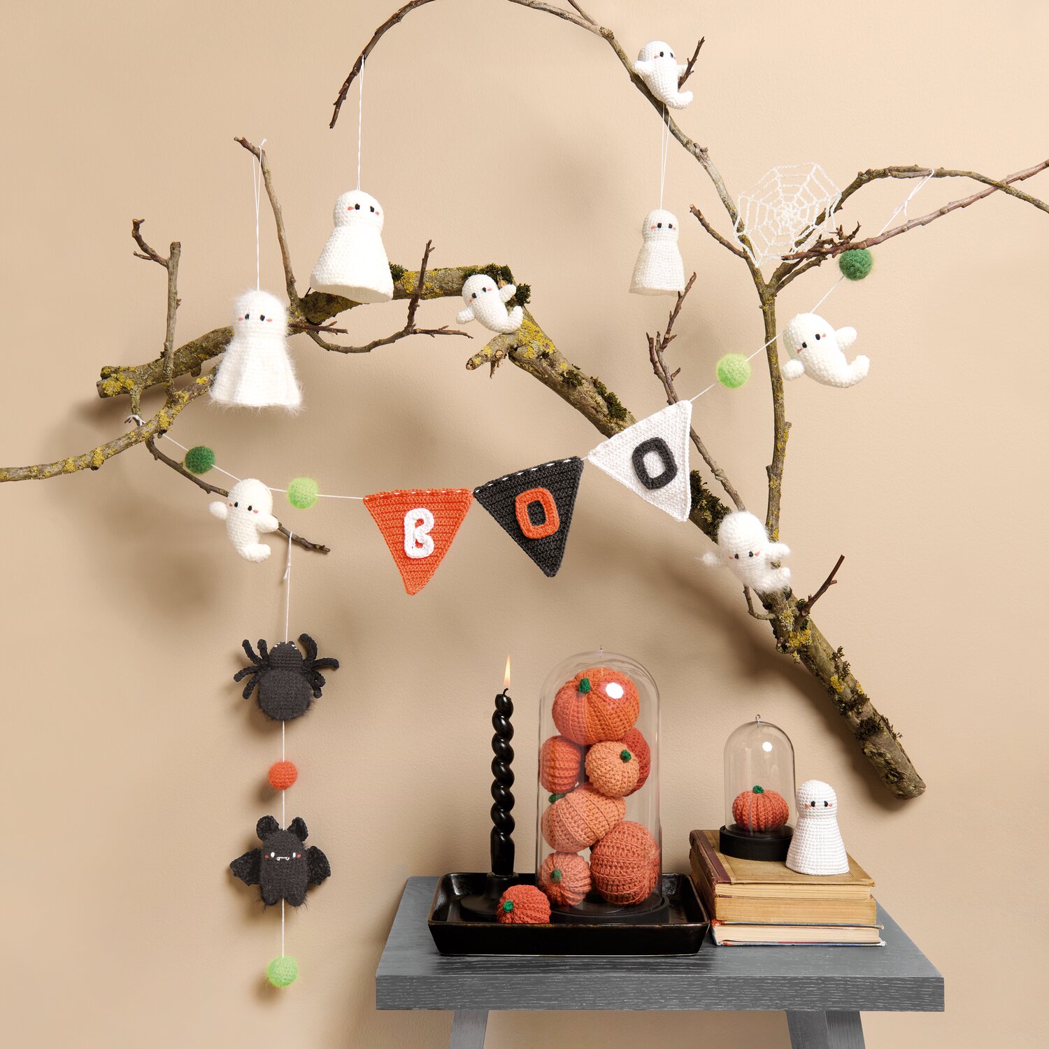 Ricorumi In the Meadow, gehäkelte Halloween-Deko mit Kürbissen, Gespenstern und Spinnen auf Ast-Arrangement, stimmungsvoll inszeniert auf kleinem Tisch