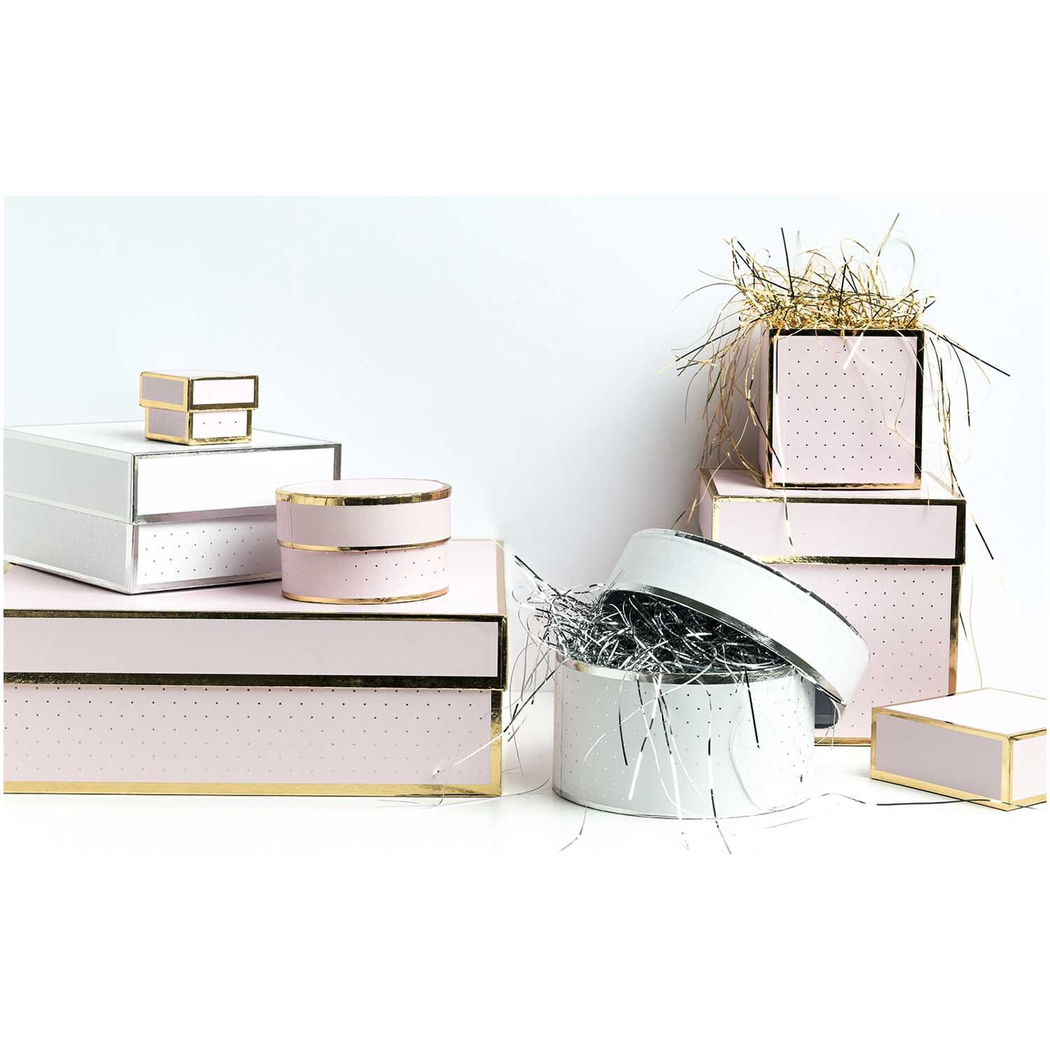 Paper Poetry Geschenkschachtel eckig rosa von Rico Design, dekoriert mit glänzendem Geschenkband und in verschiedenen Größen gestapelt.