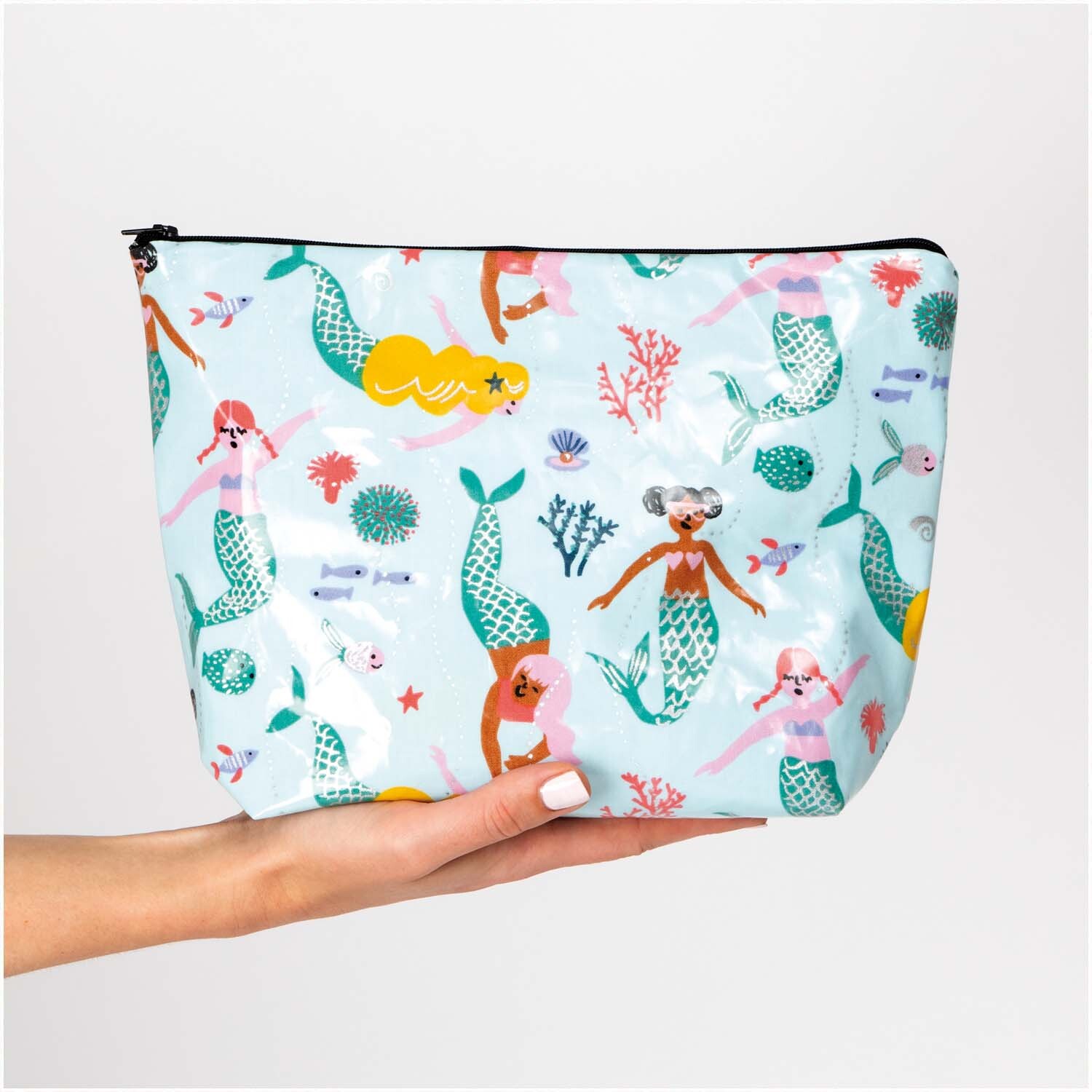 Druckstoff beschichtet Mermaid Meerjungfrau-neon Hot Foil 25x70cm: Kosmetiktasche mit buntem Meerjungfrauen-Design, gehalten von einer Hand.