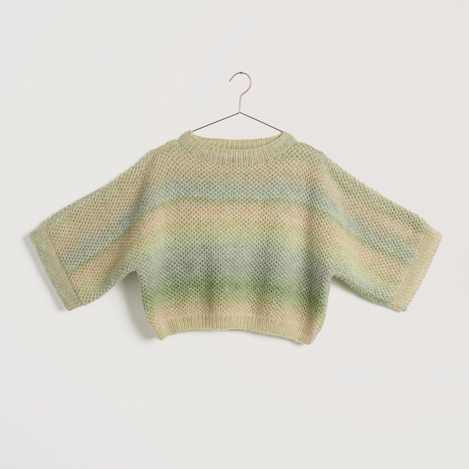 Strickset Pullover Modell 19 aus Lovewool No. 22 in sanften Pastelltönen auf einem Kleiderbügel.