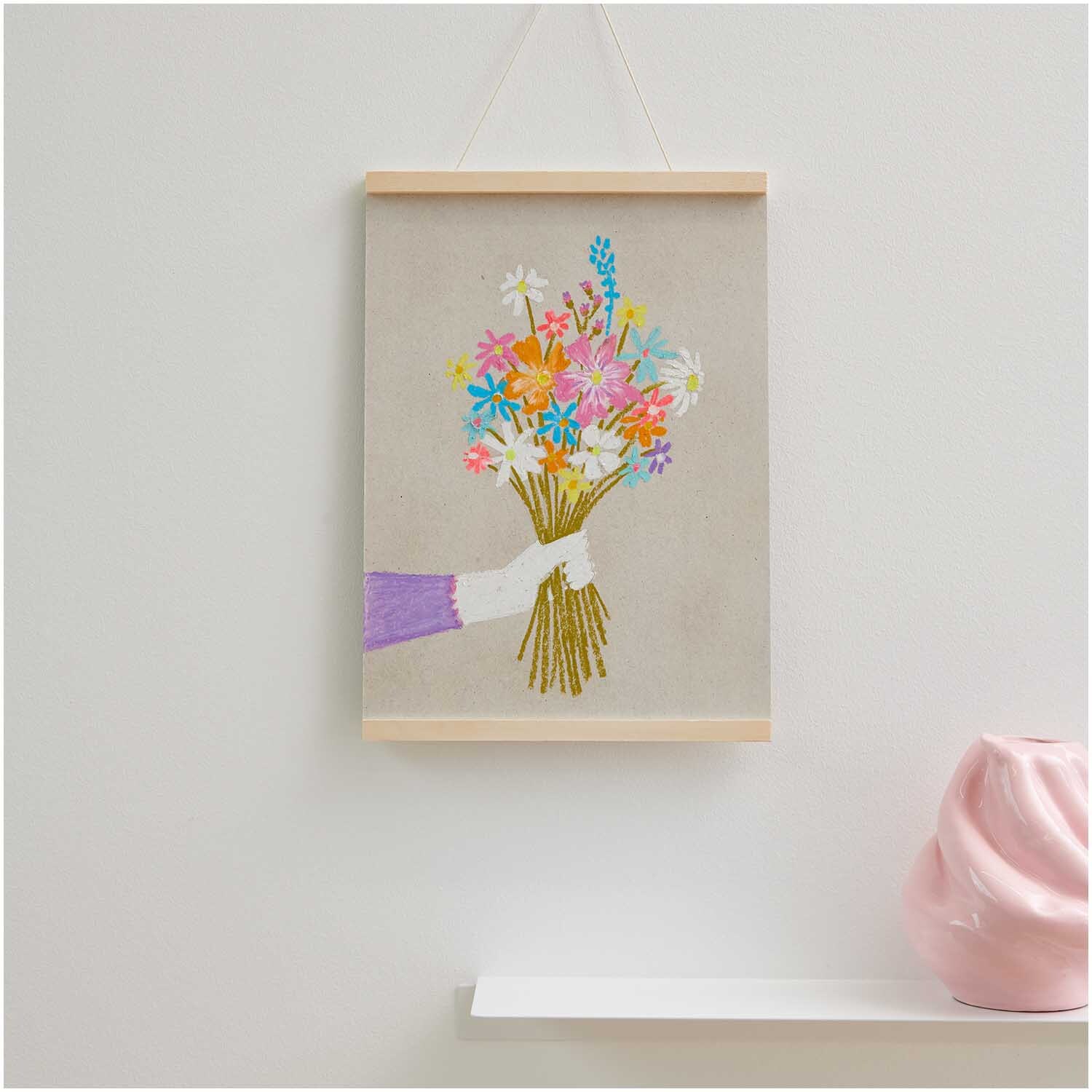 Anleitung Blumen mit Pastellkreiden malen: Ein Bild zeigt eine Hand, die einen bunten Blumenstrauß hält, aufgehängt an einer Wand.