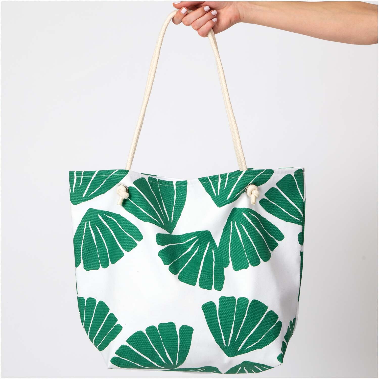 Druckstoff Canvas Aloha Blätter 50x140cm: Tasche mit grünem Blattmuster, gehalten von einer Hand.