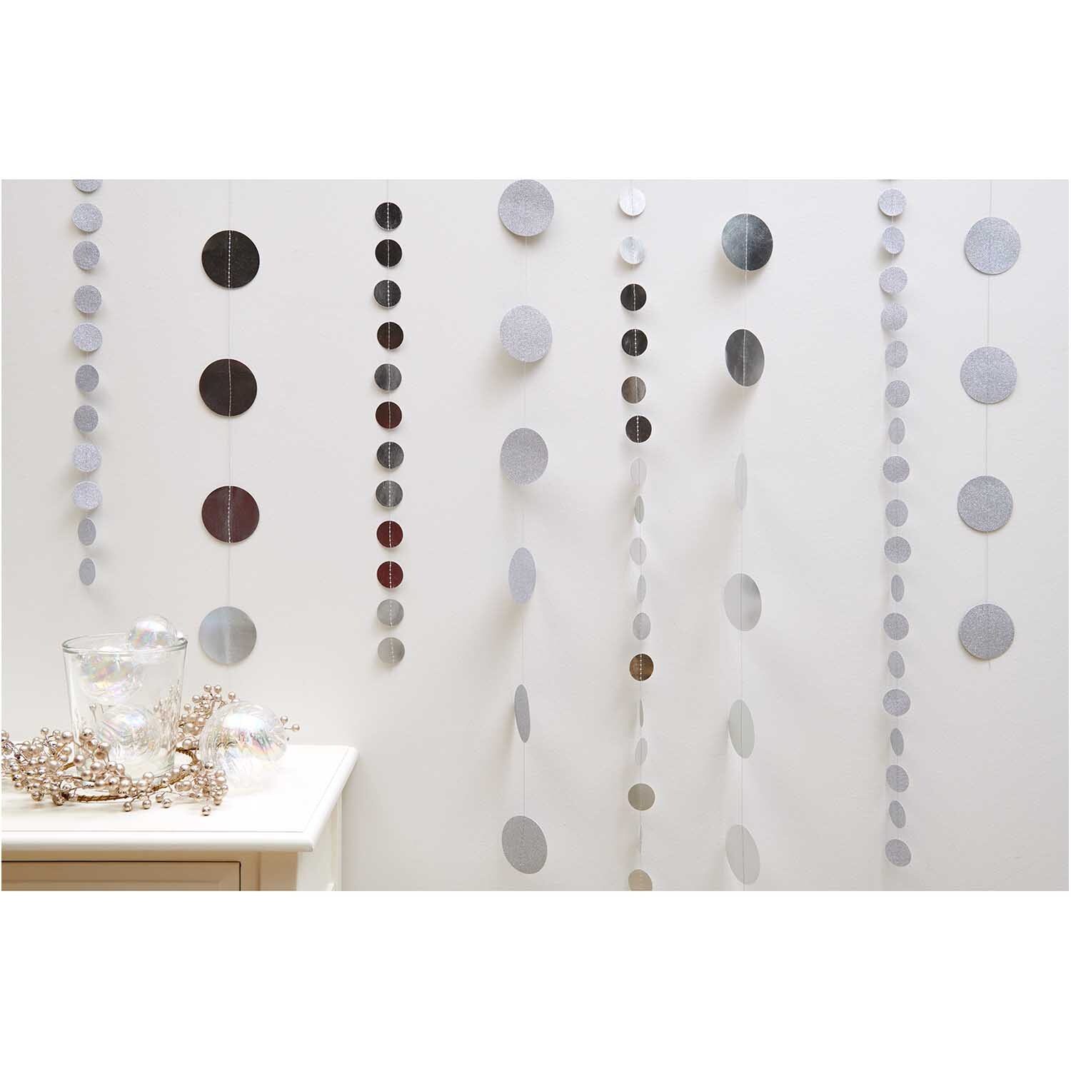 Genähte Girlande Kreise 8cm Glitter-silber 1,7m von Rico Design, dekorativ an einer Wand hängend.