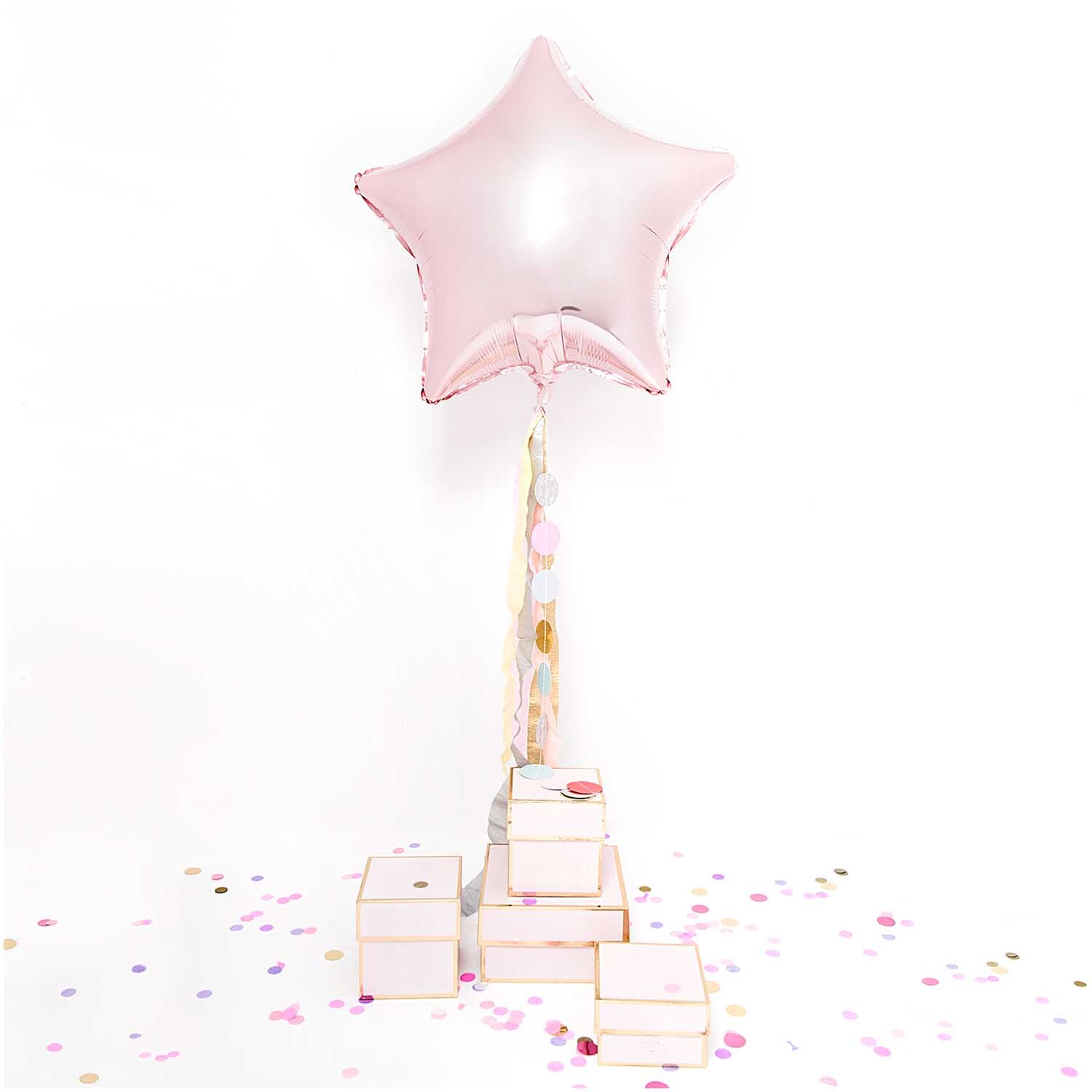 Genähte Girlande Kreise 2m und rosa Folienballon Stern 36cm von Rico Design, umgeben von Konfetti und Geschenkboxen.