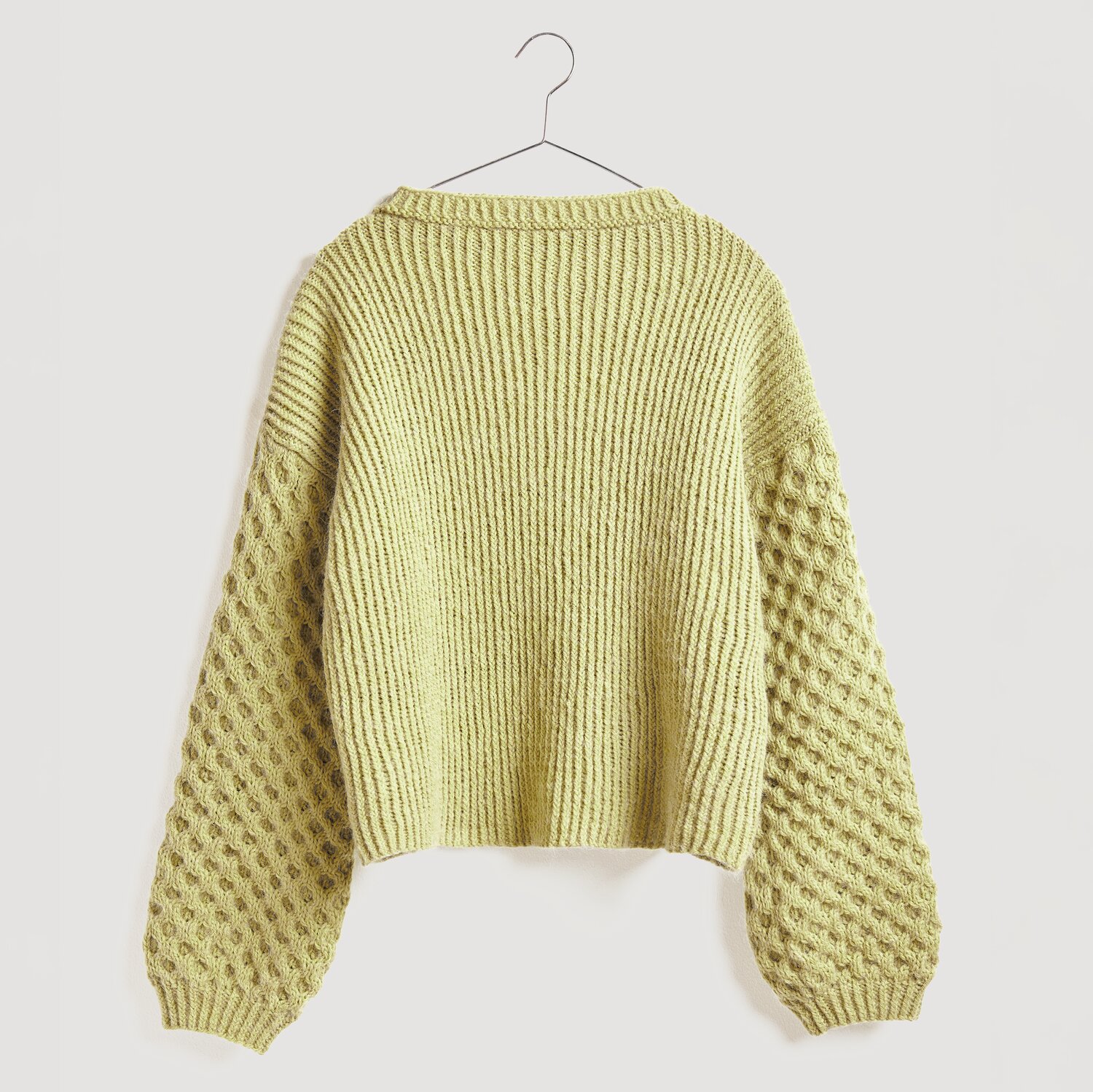 Gestrickter Pullover in Gelb auf Bügel