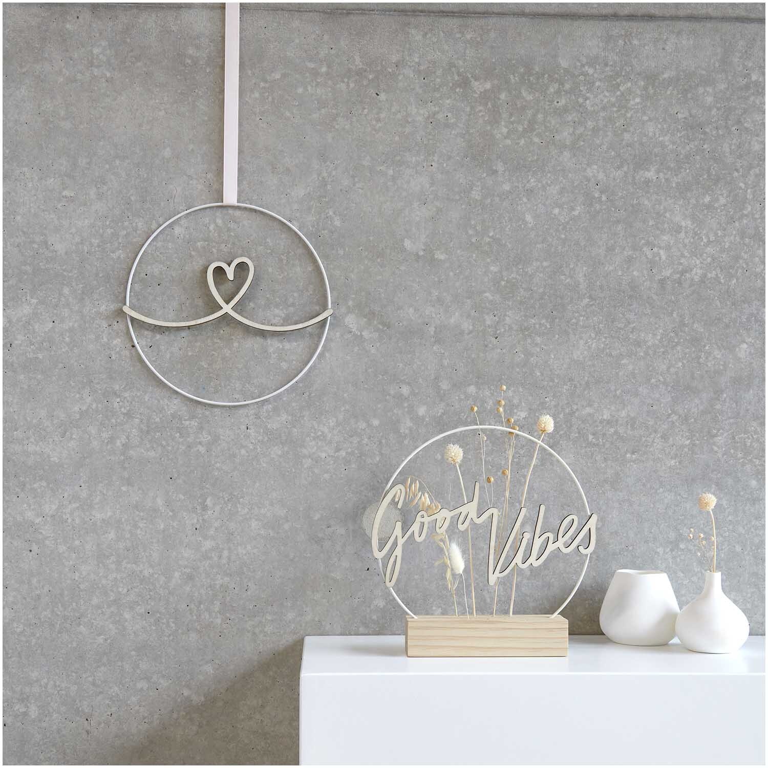 Holzschriftzug magnetisch "Good Vibes" 26x13cm von Rico Design auf weißem Regal vor grauer Wand mit Dekoration.