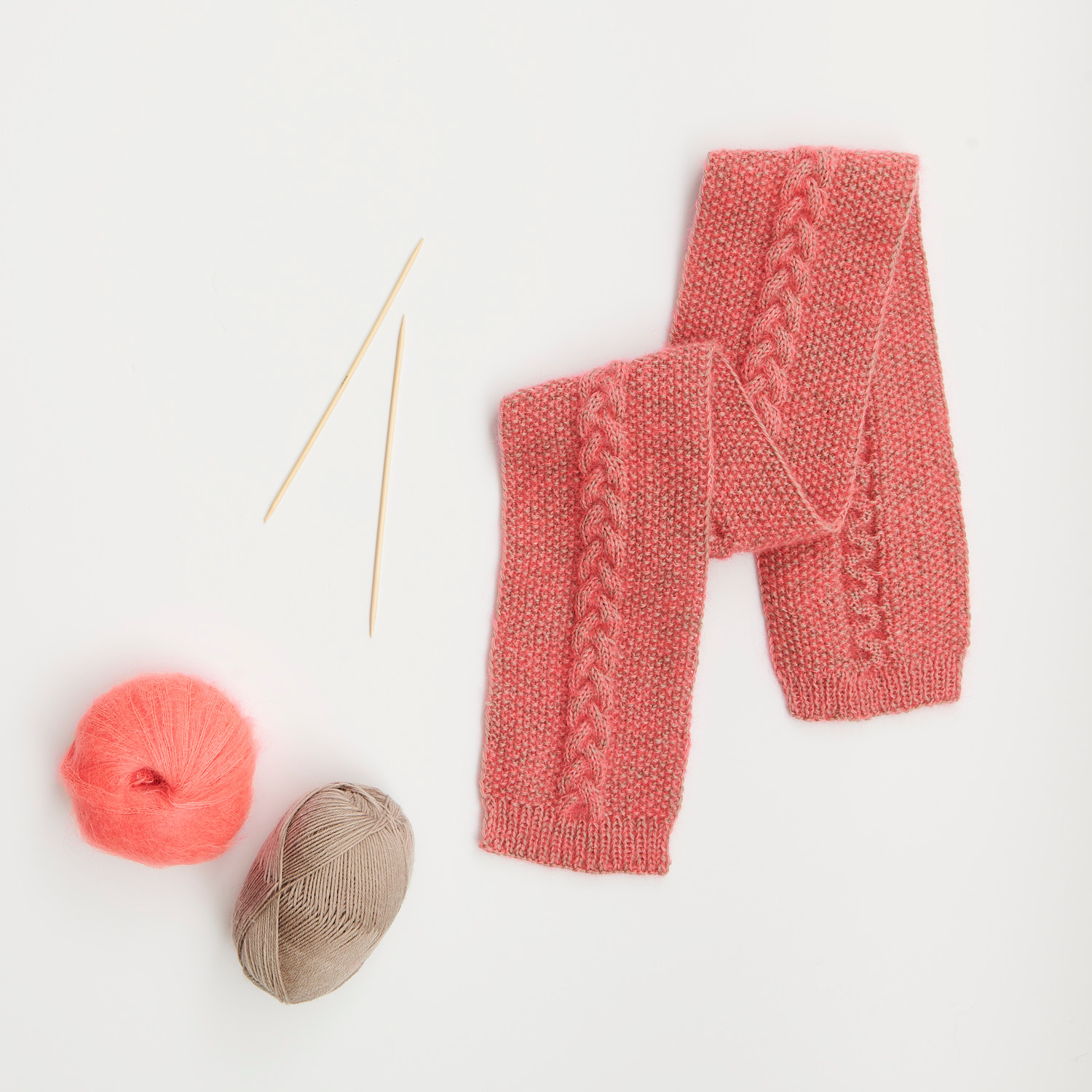 Mini Tücher Special: Rosa gestrickter Schal mit Zopfmuster, Wolle und Stricknadeln von Rico Design.