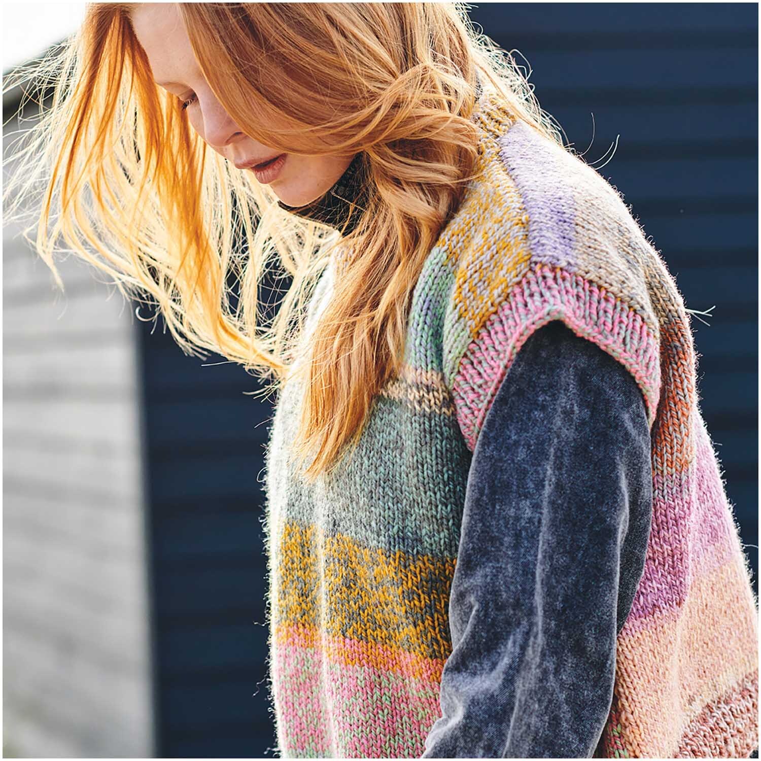 Creative Chic-Unique: Frau trägt gestrickten Pullover in bunten Streifen, ideal für modische Herbsttage.