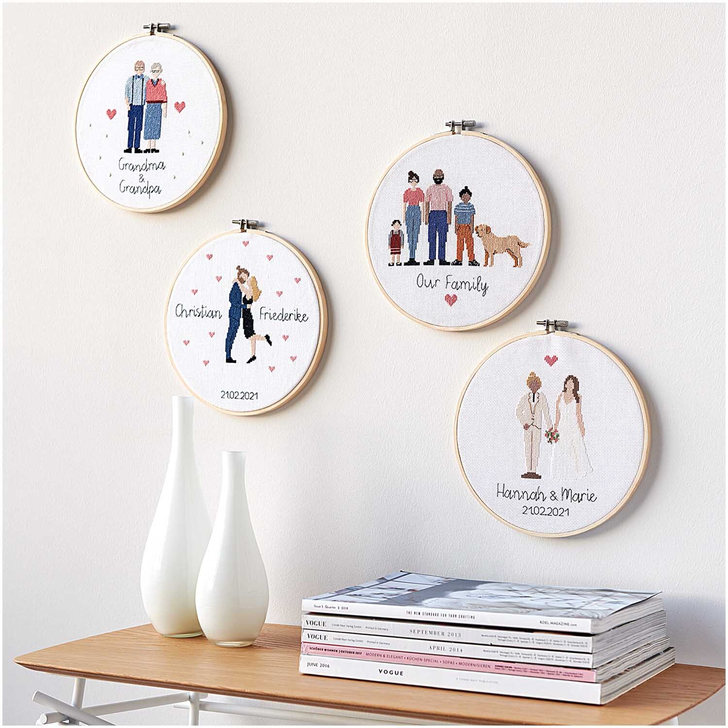 Figurico Stickpackung Grandma & Grandpa 20cm zeigt gestickte Familienporträts in Holzrahmen an einer Wand.