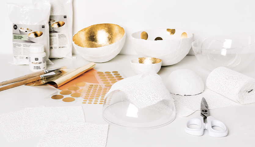 Bastelanleitung Dekoschale aus Modellierbinden: Materialien und Werkzeuge für kreative DIY-Projekte, inklusive goldener Akzente und Modellierbinden.