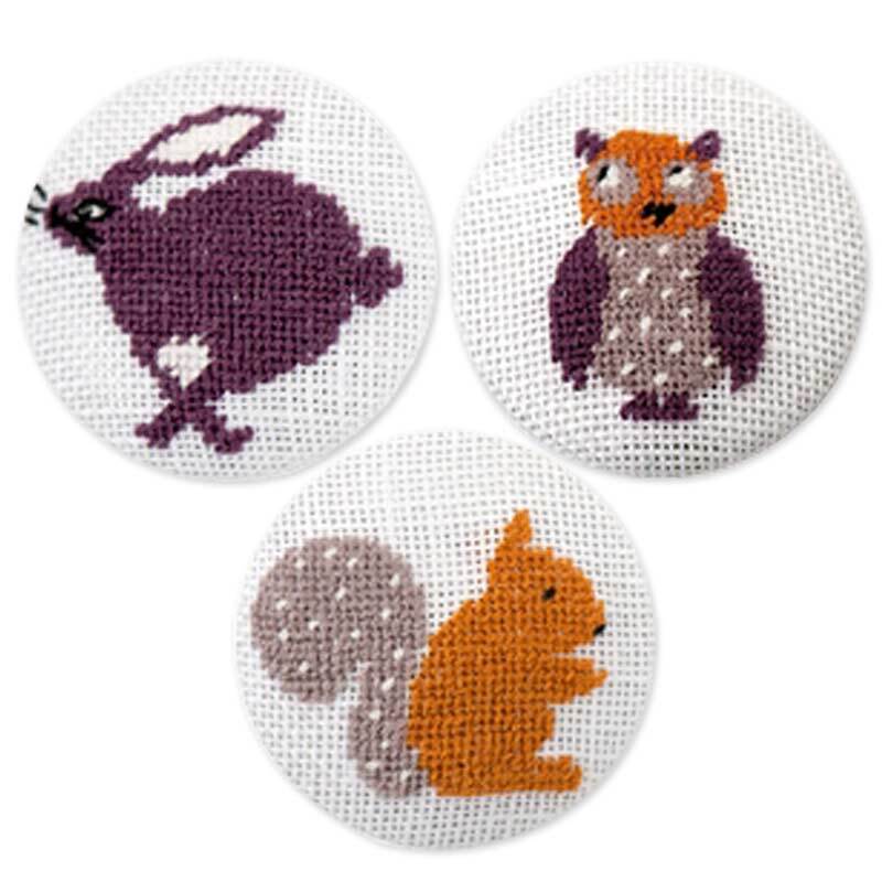 Stickpackung Knöpfe Eule-Eichhörnchen-Hase zeigt bunte Tiermotive auf weißem Stoff von Rico Design.