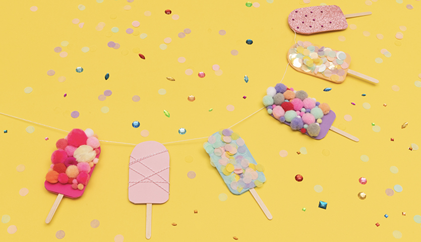 Bastelanleitung Eis-Girlande: Bunte Eis am Stiel aus Papier und Pompons auf gelbem Hintergrund mit Konfetti.
