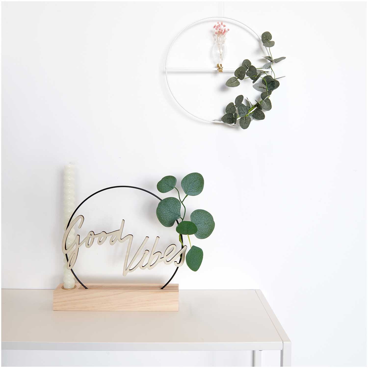 Metallring mit Querstrebe Ø25cm von Rico Design, dekoriert mit Eukalyptusblättern und Kerze.