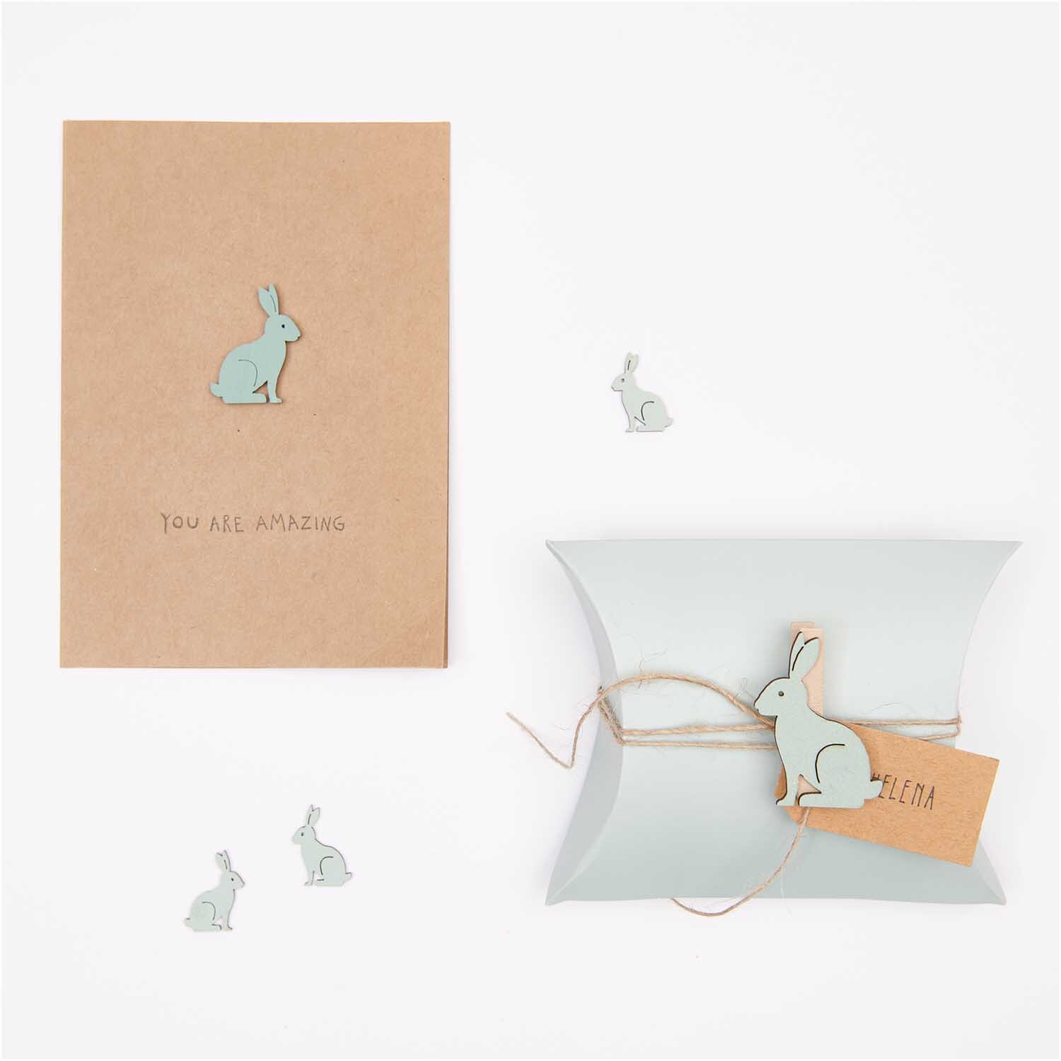 Holzsticker Hase klein 12 Stück von Rico Design in Mint auf einer Karte und Geschenkbox arrangiert.