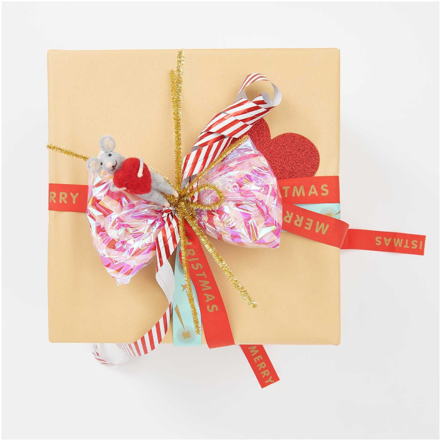 Luftschlangen Streifen rot-weiß 3,8m von Rico Design dekorieren ein Geschenk mit buntem Papier und goldenen Akzenten.