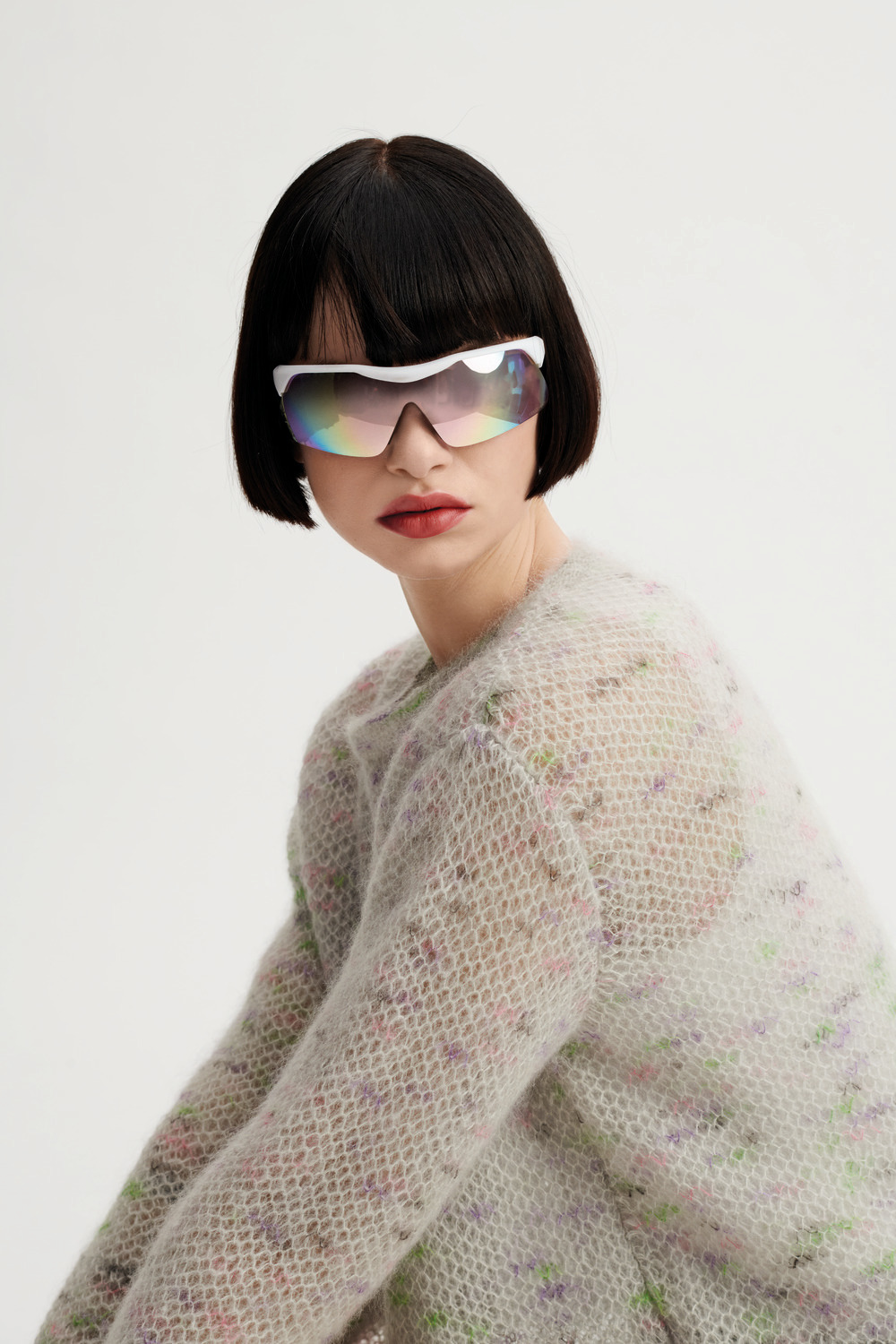 Strickset Pullover Modell 01: Frau mit futuristischer Sonnenbrille trägt einen flauschigen Pullover.