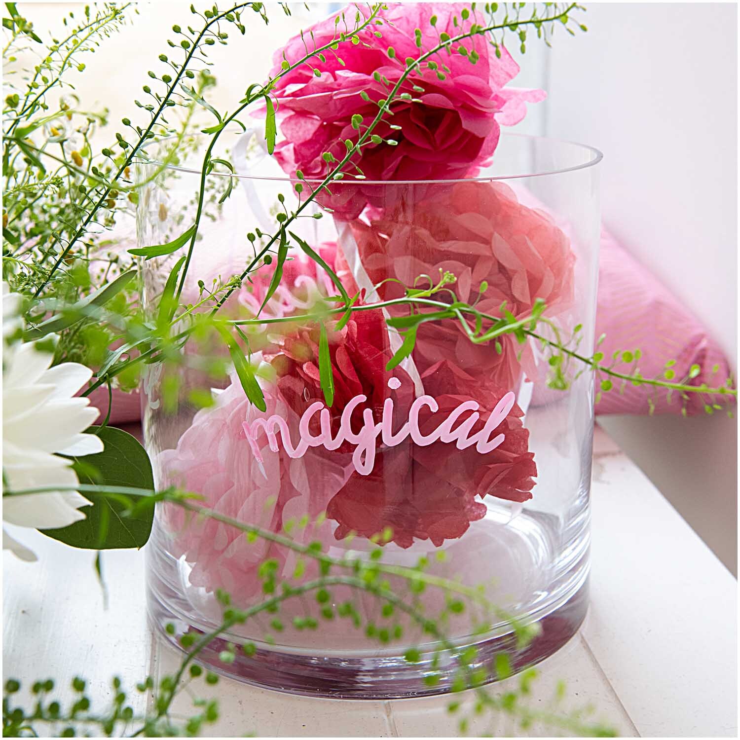Kreidestifte Flüssigkreide Set Regenbogen: Glasvase mit rosa Blumen und Schriftzug "magical", dekoriert mit grünen Zweigen.