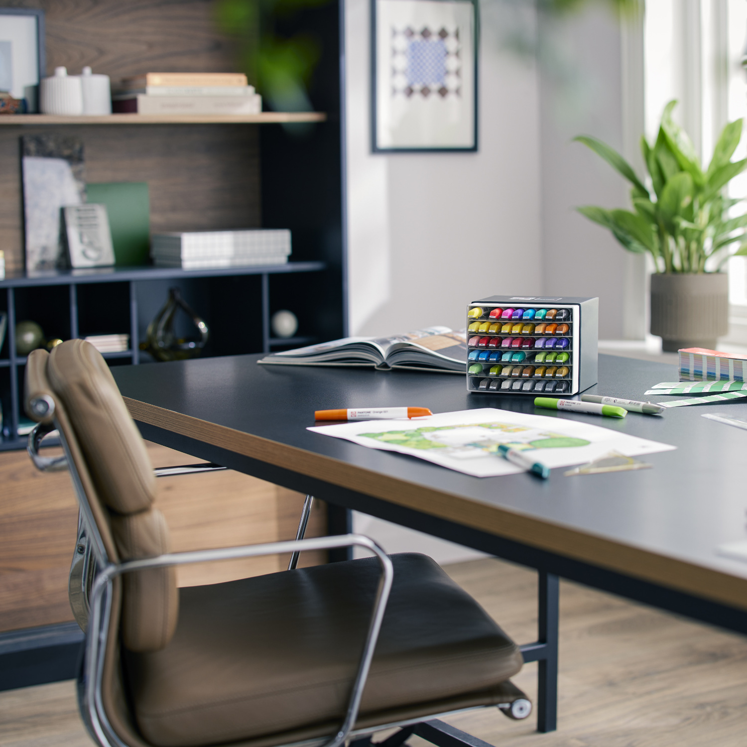 Talens | Pantone Marker Set: Ein 54-teiliges Set auf einem modernen Schreibtisch in einem hellen Raum.