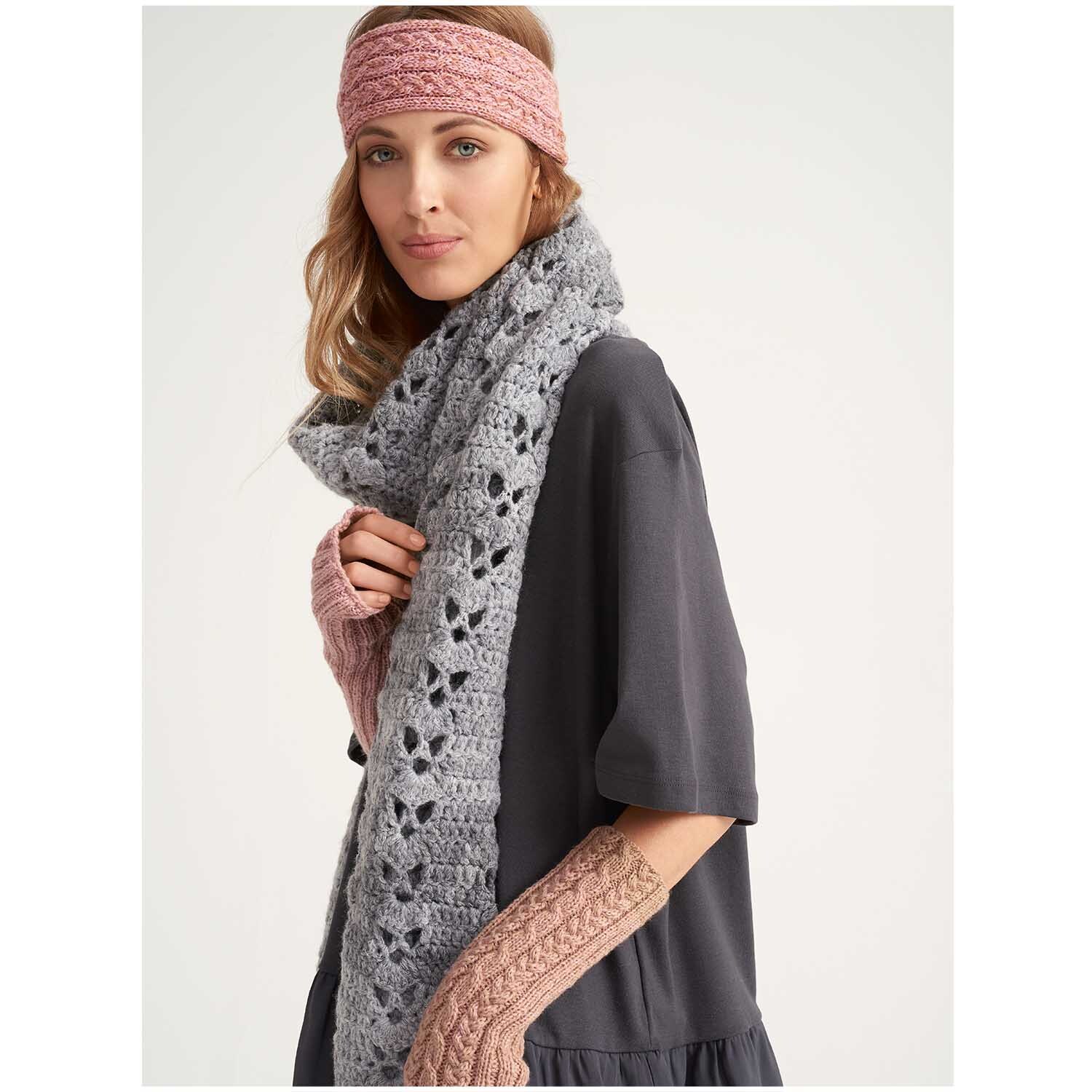 Creative Light Melange Glitz: Frau trägt gestricktes Stirnband, Schal und Armstulpen in Grau und Rosa. Ideal für stilvolle Wintermode.