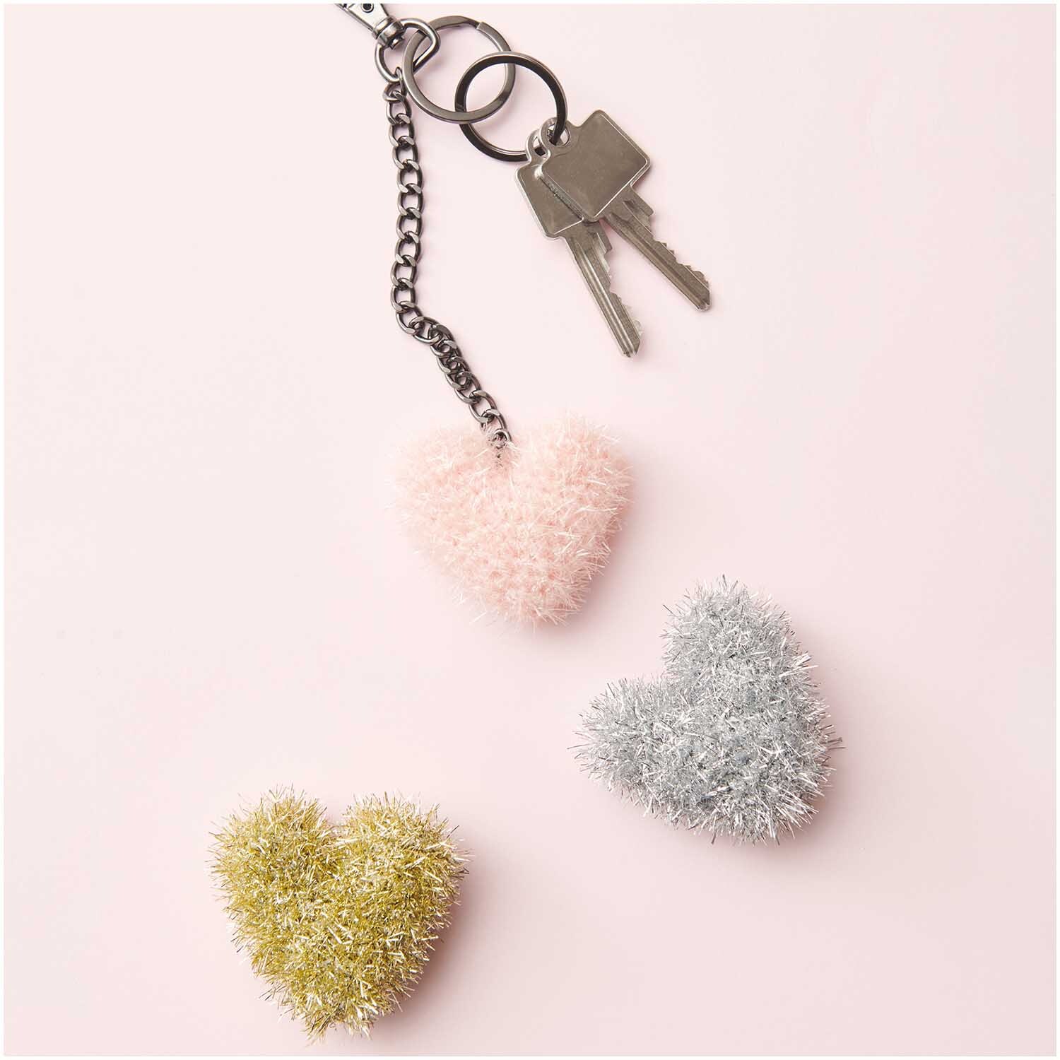 Creative Bubble Set Good Luck! Flauschige Herzanhänger in Rosa, Silber und Gold von Rico Design auf rosa Hintergrund.
