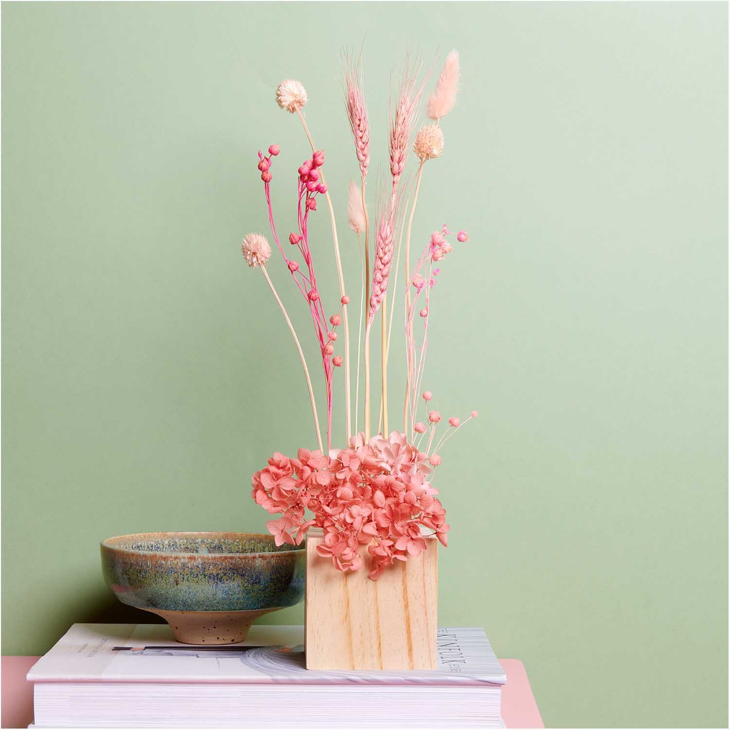 Getrockneter Flachs pink 60-75cm 100g von Rico Design in einer Vase vor grünem Hintergrund, dekorativ arrangiert.