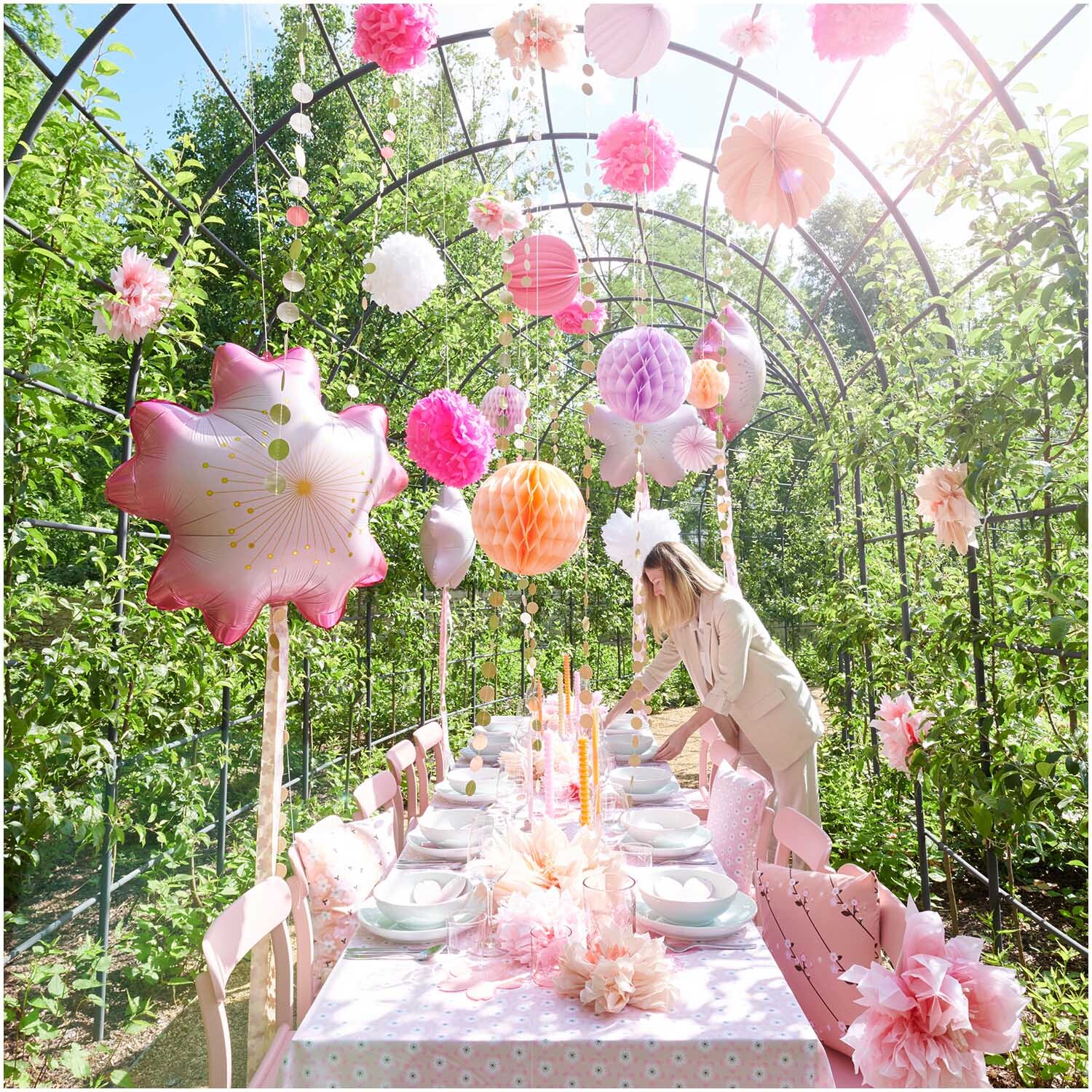 Meterware Baumwoll-Popelin Kirschblüten Mix: Ein festlich dekorierter Tisch im Garten mit rosa und weißen Papierlaternen von Rico Design.