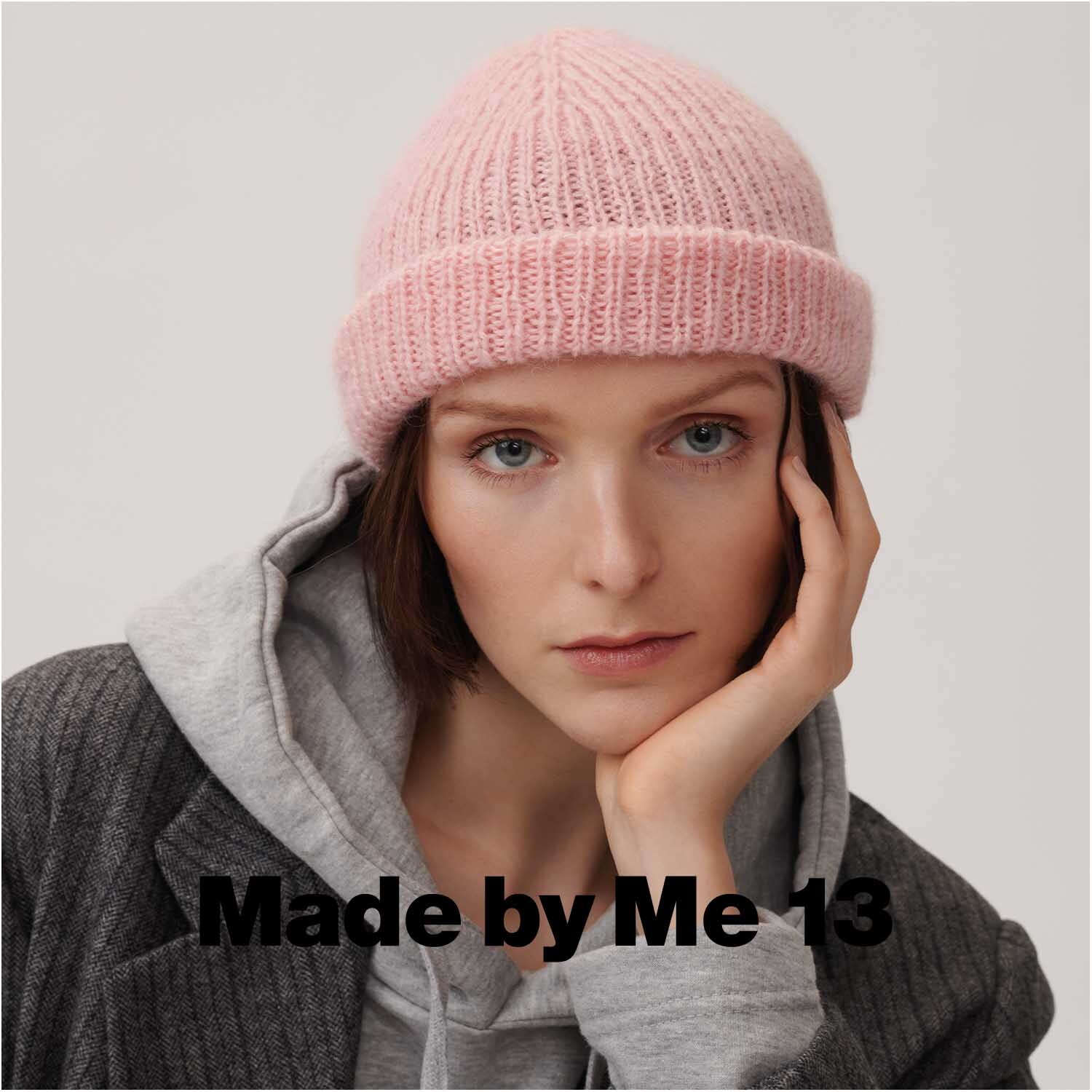 Luxury OMG: Frau trägt rosa Strickmütze, kombiniert mit grauem Hoodie und Mantel. Perfekt für stilvolle Wintermode.