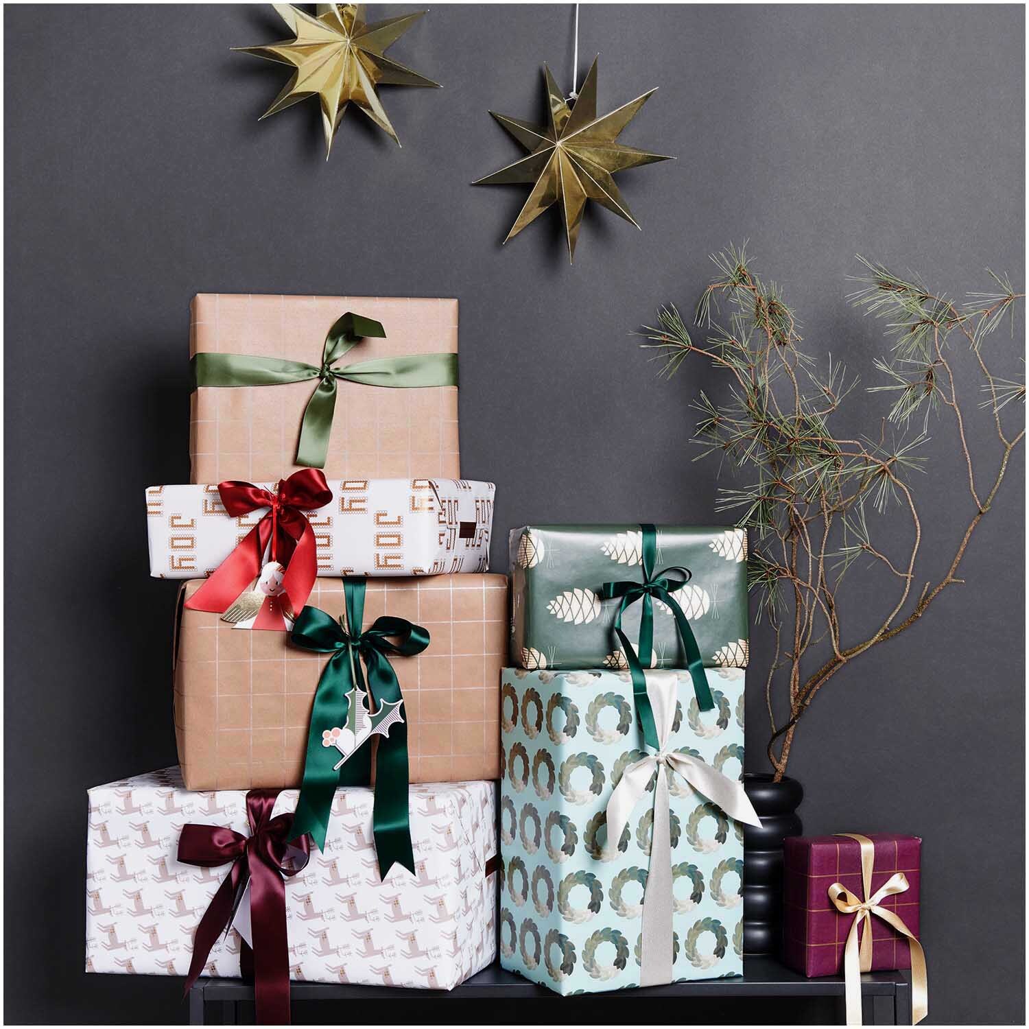 Paper Poetry Geschenkpapier zeigt elegant verpackte Geschenke in verschiedenen Mustern und Farben.