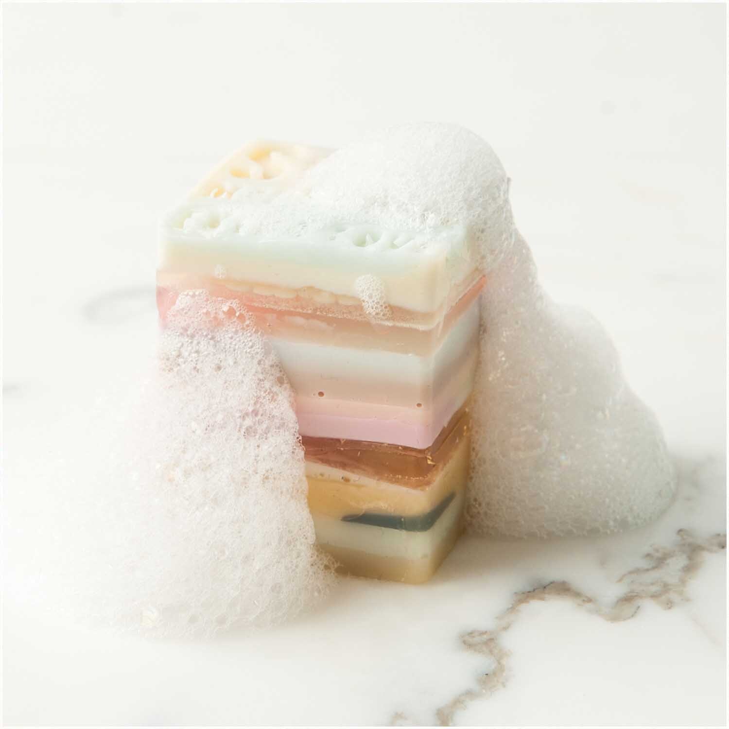 Made by Me Anleitungsheft Soap Hygge: Bunte Seifenstücke mit Schaum auf weißem Hintergrund, von Rico Design.