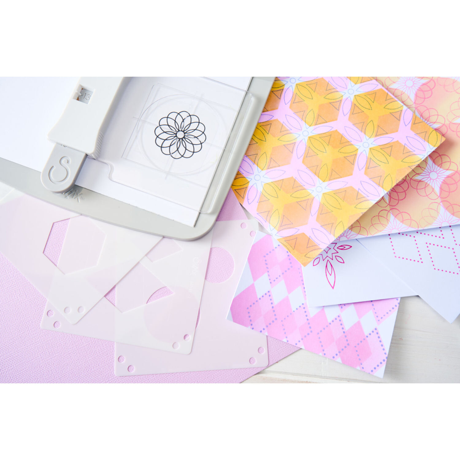Making Tool Print and Pattern Starter Kit von Sizzix mit weißem Stanzwerkzeug, transparenten Schablonen und bunten Papierbögen mit grafischen Mustern