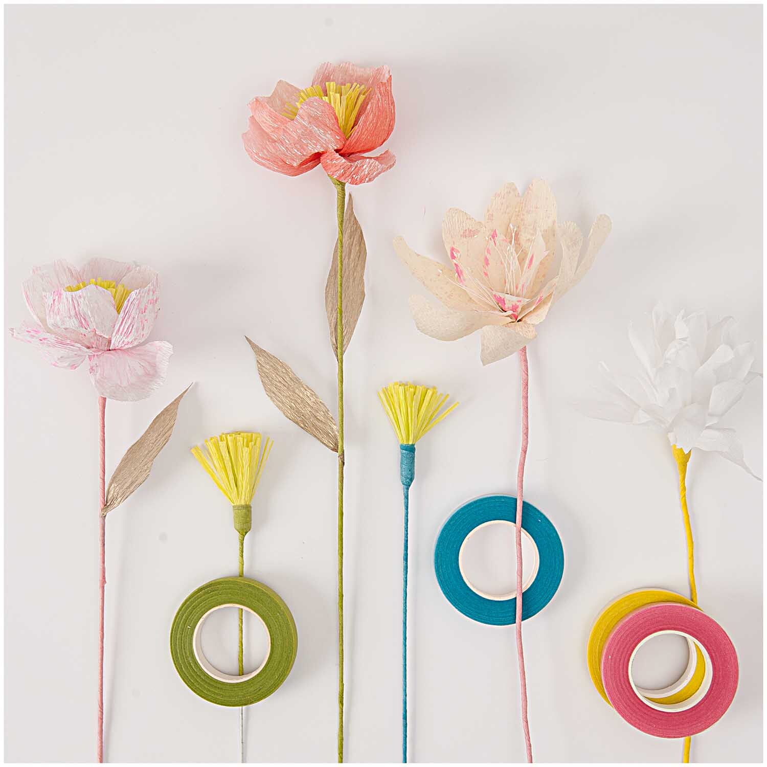Kreppwickelband 12mm 27,5m in Türkis von Rico Design neben bunten Papierblumen und weiteren Bändern.