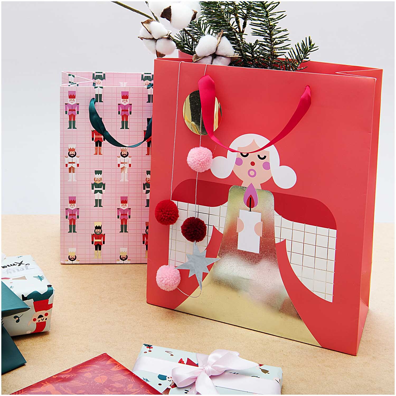 Paper Poetry Geschenktüte mit Engelmotiv, ideal für festliche Anlässe, dekoriert mit Pompons.