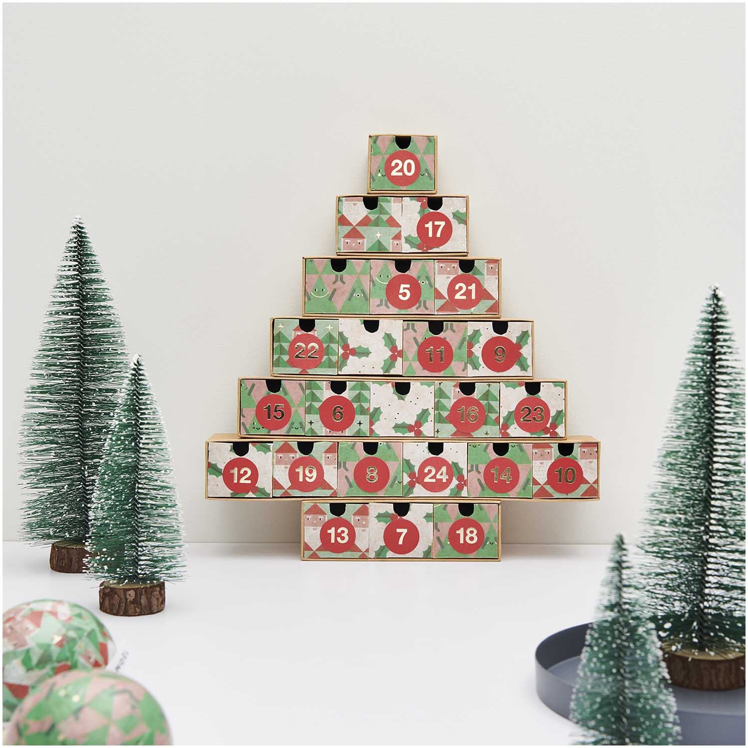 Paper Poetry Paper Patch Papier Ilex 30x42cm: Adventskalender in Tannenbaumform mit dekorativen Zahlen und grünen Miniaturbäumen.