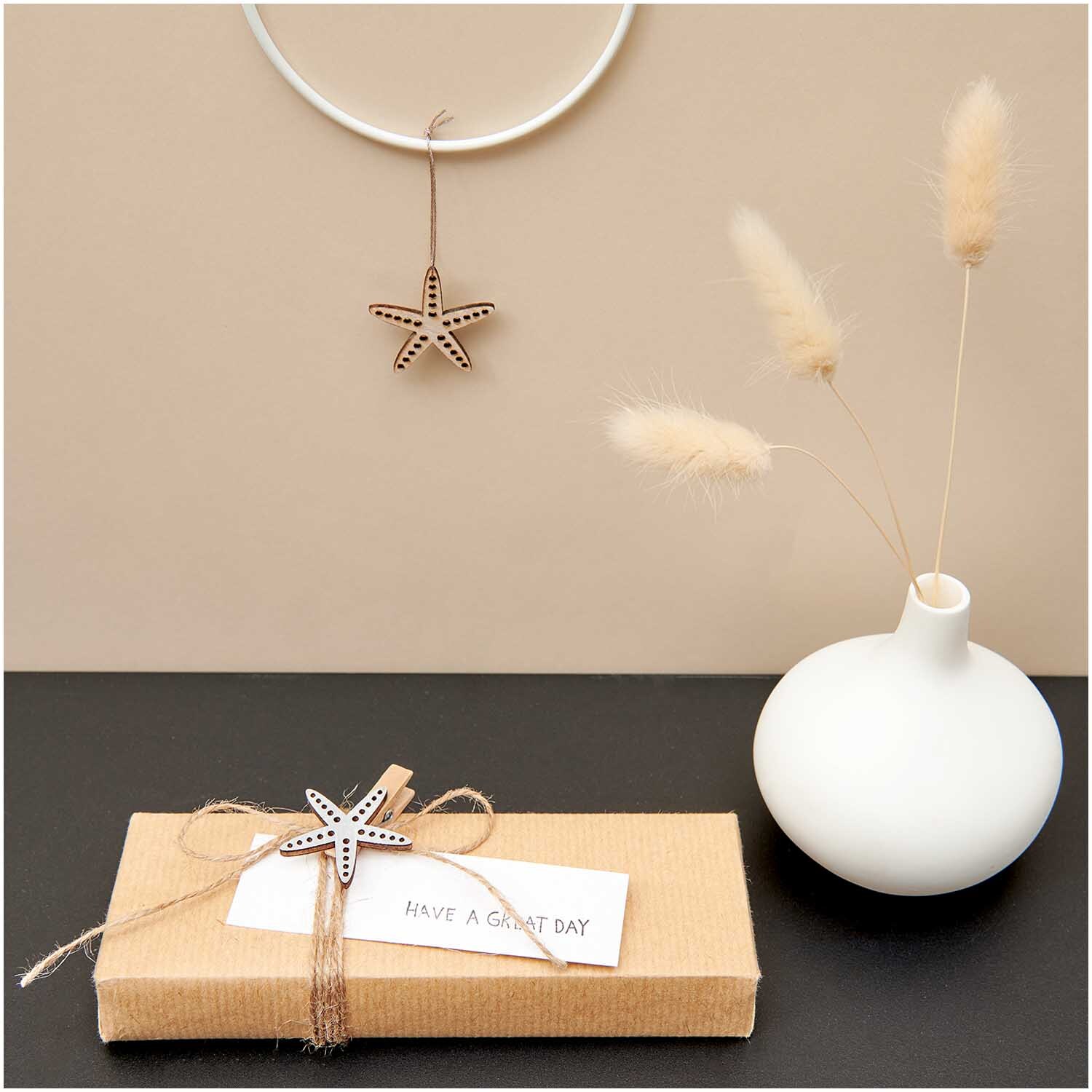 Holzstreu Fisch & Seestern Mix natur 36 Stück: Dekoratives Set mit Seestern-Anhänger und Geschenkbox auf schwarzem Tisch. Ideal für kreative Projekte.